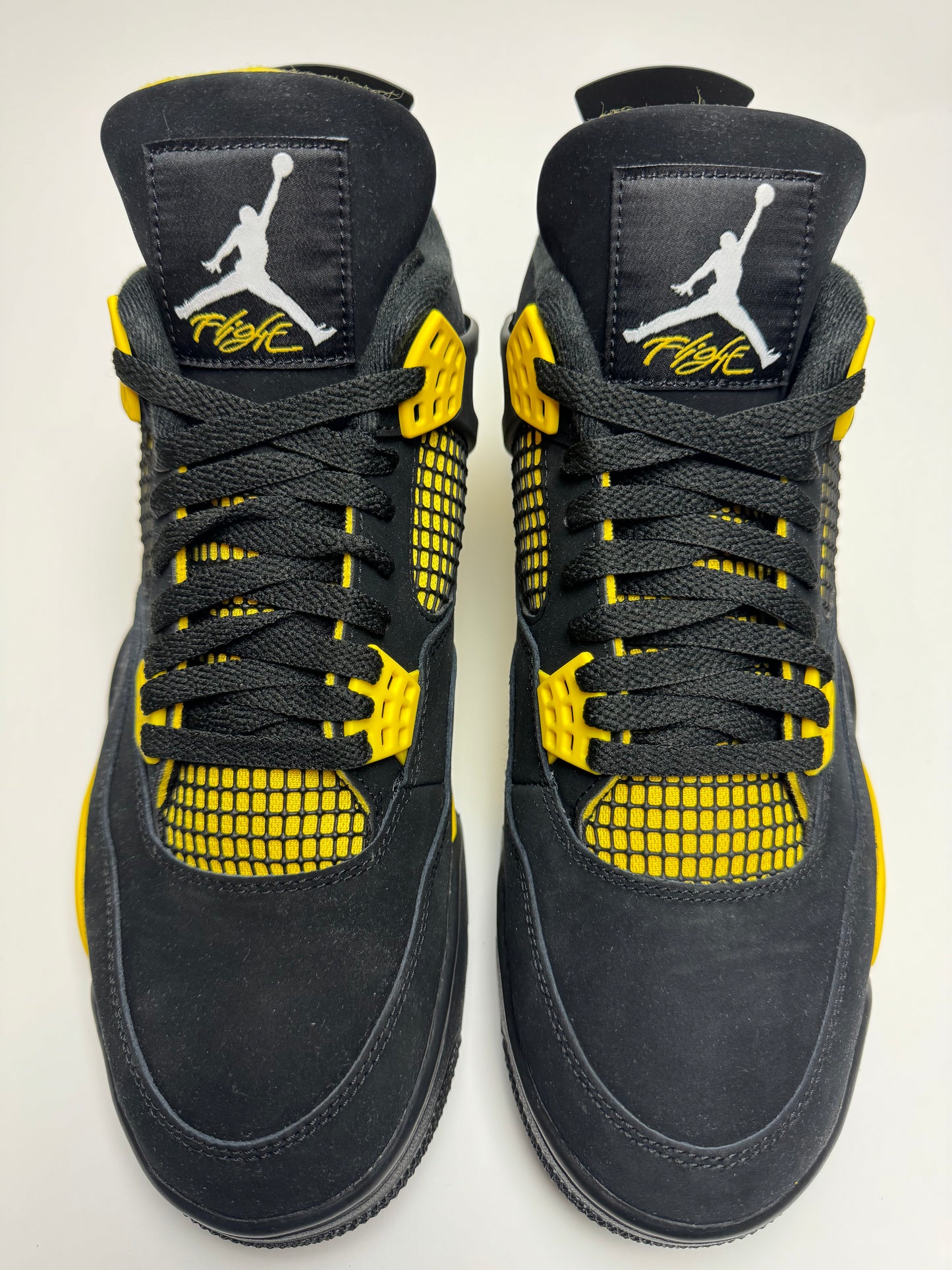 Detailansicht der Zunge – Flight-Tag in Tour Yellow auf schwarzem Nubuck, prägnantes Jumpman-Logo