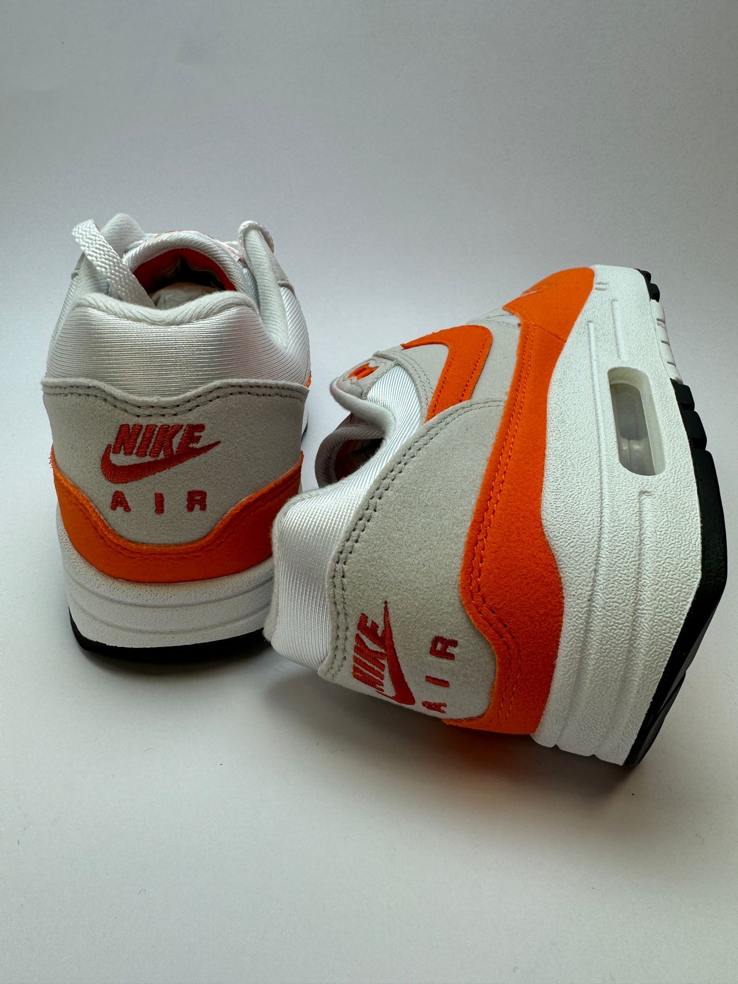 Detailansicht der Zunge – Nike Air Max 1 Safety Orange mit gewebtem Branding in Safety Orange