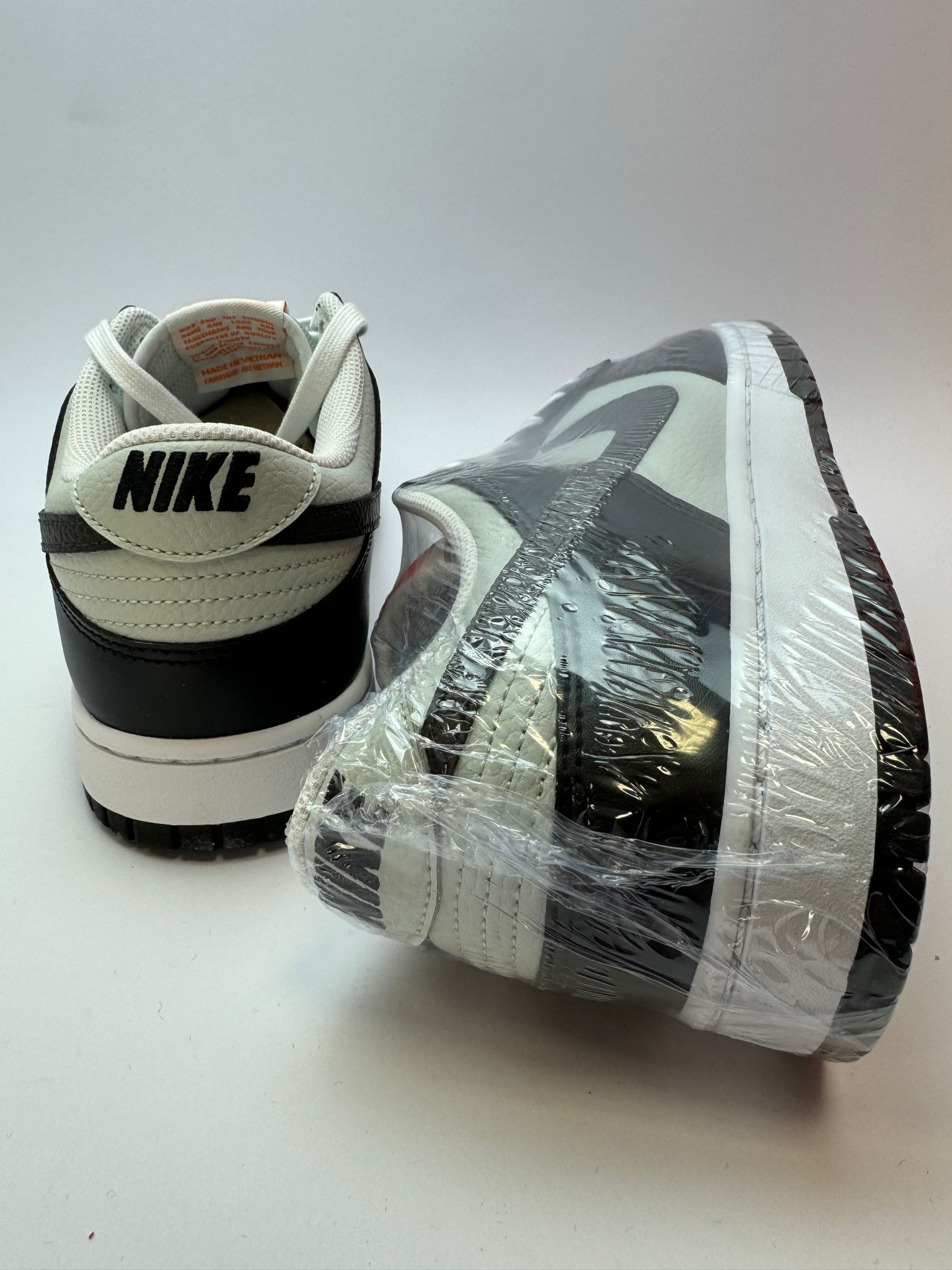 Rückansicht des Sneakers – Nike Dunk Low Black/Total Orange mit gepolstertem Heel-Tab und schwarzem Leder