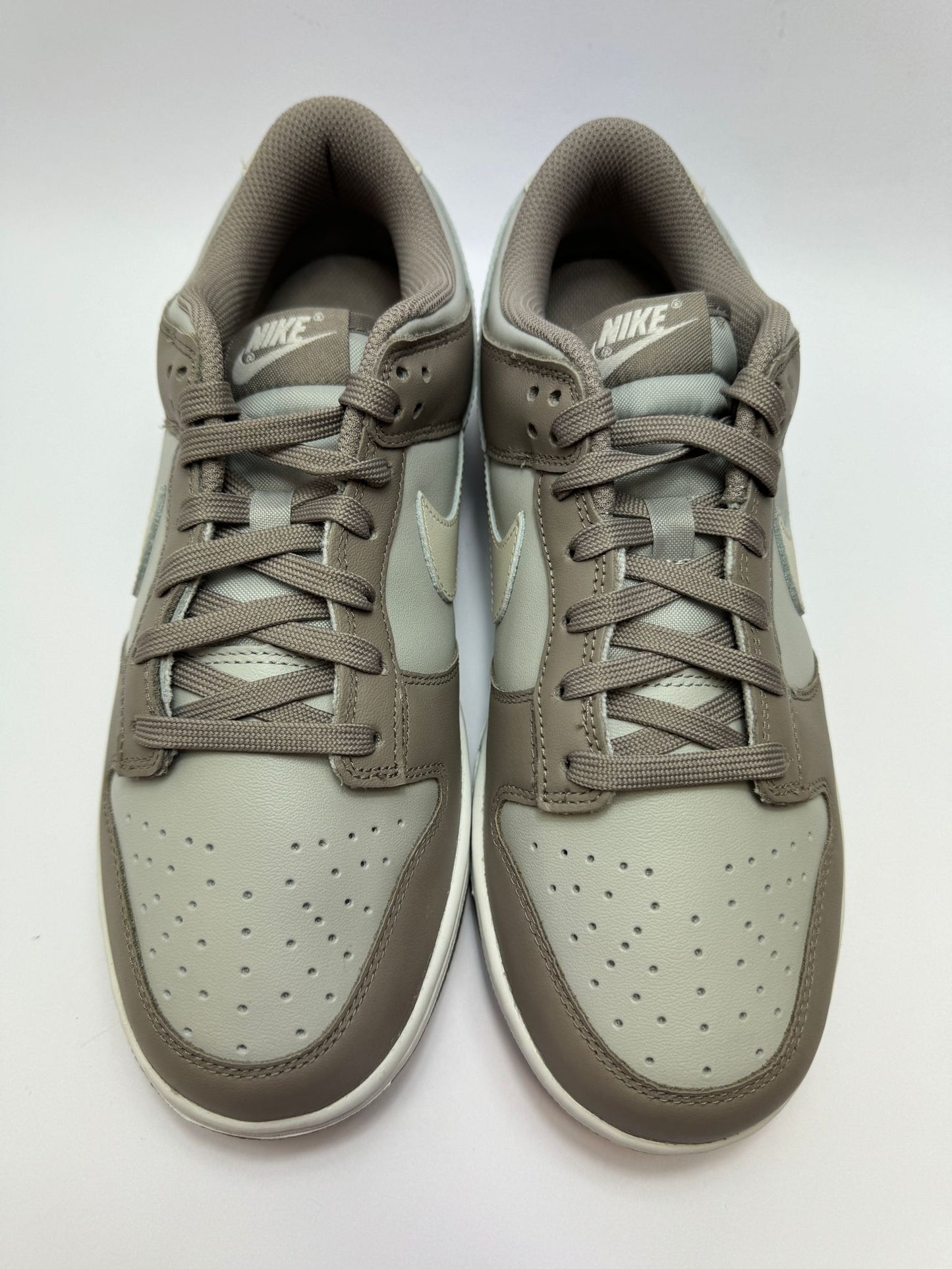 Detailansicht der Zunge – Nike Dunk Low Bone Beige mit gewebtem Dunk-Logo