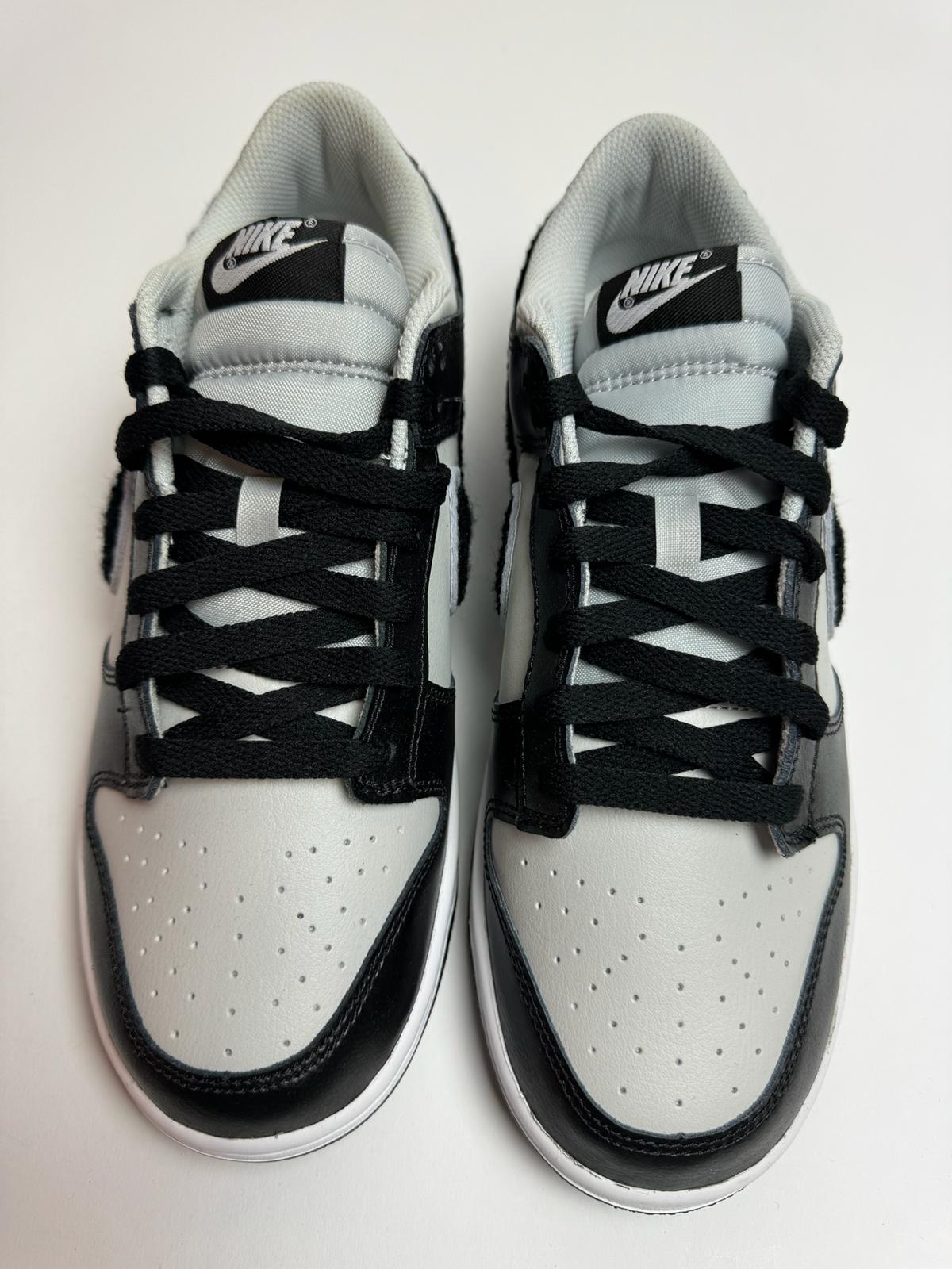 Detailansicht der Zunge – Nike Dunk Low Chenille Swoosh Black Grey mit gesticktem Dunk-Logo und Chenille-Akzenten