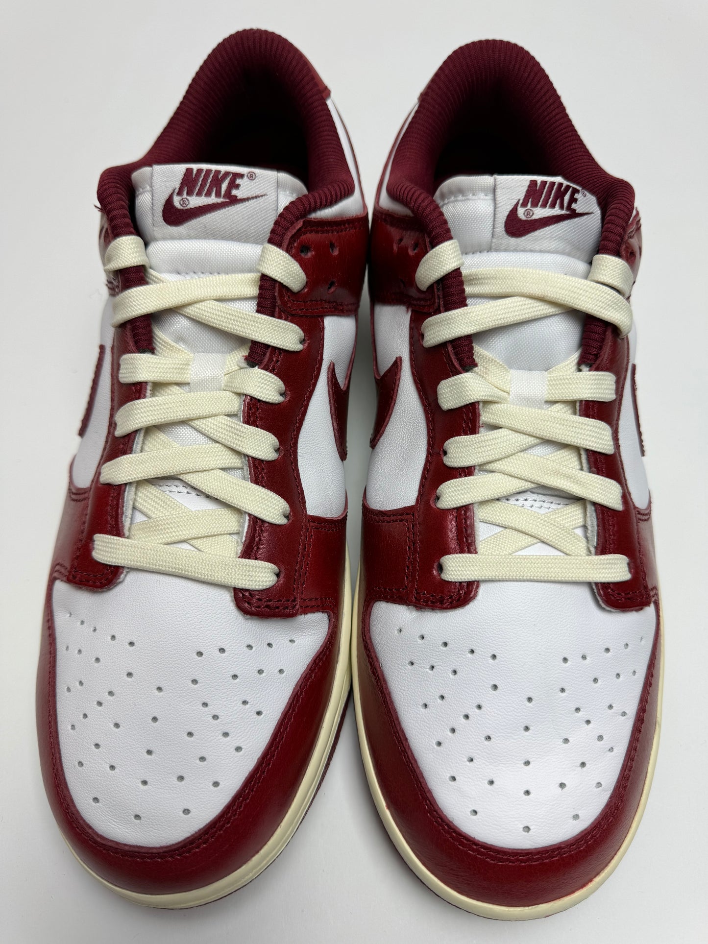 Detailansicht der Zunge – Nike Dunk Low Vintage Team Red mit Nike‑Tag in Team‑Red auf Action‑leathern Zunge