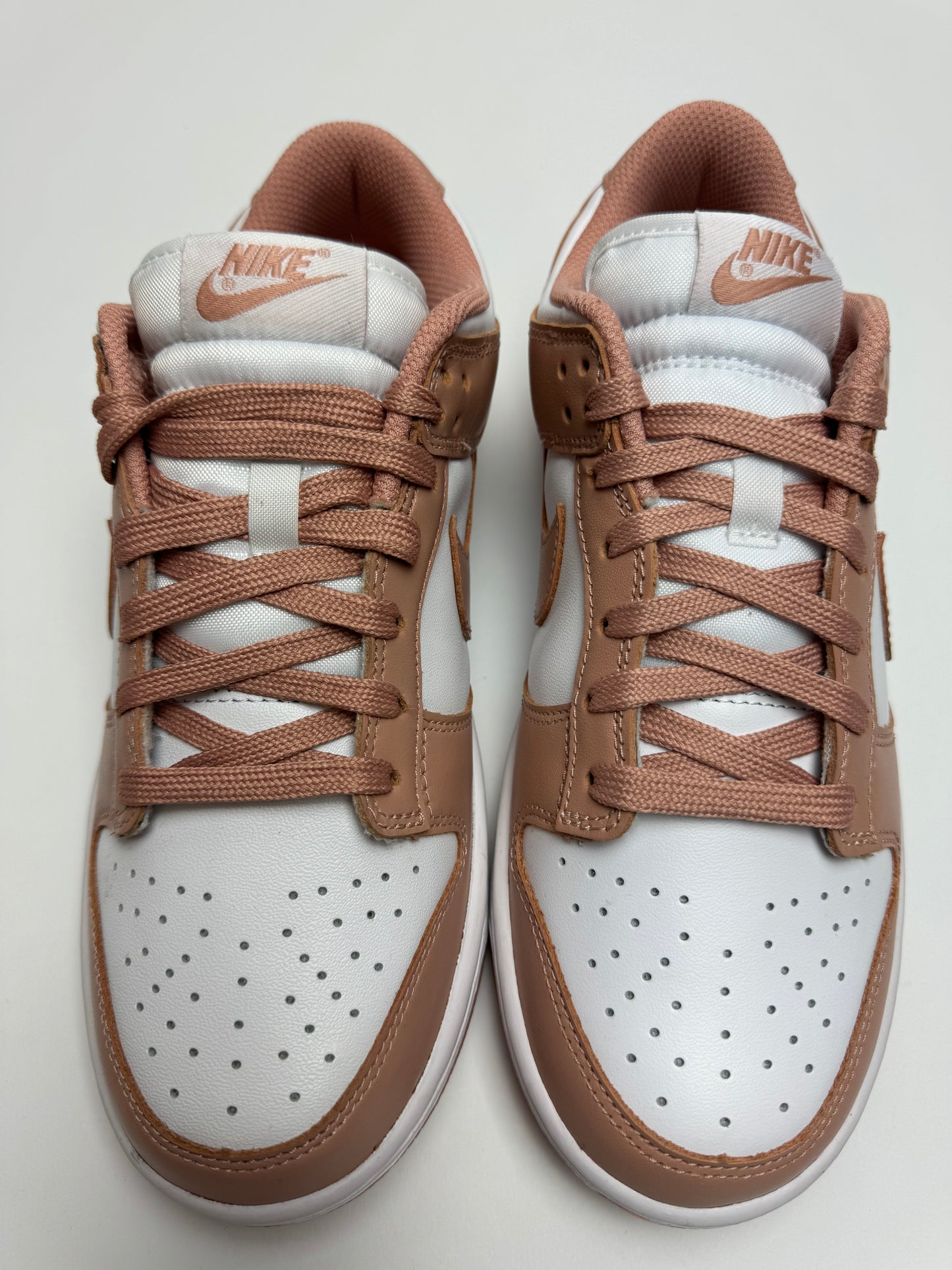 Detailansicht der Zunge – Nike Dunk Low Rose Whisper mit gewebtem Nike-Branding in Rosé und padded Collar