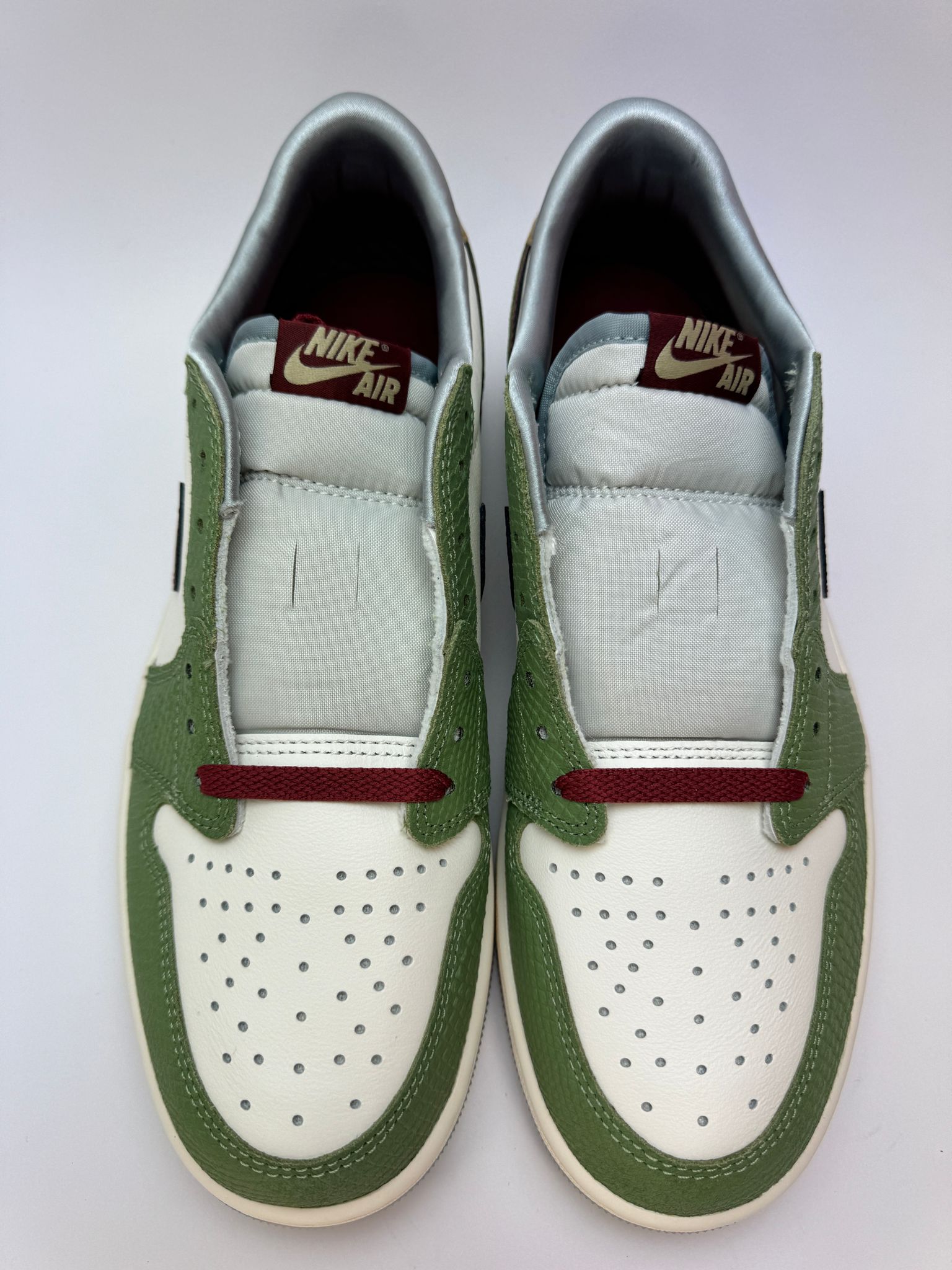 Detailansicht der Zunge – Jordan 1 Low Year of the Dragon mit luxuriösem Satin-Futter und Jumpman-Charm/Zungenlabel