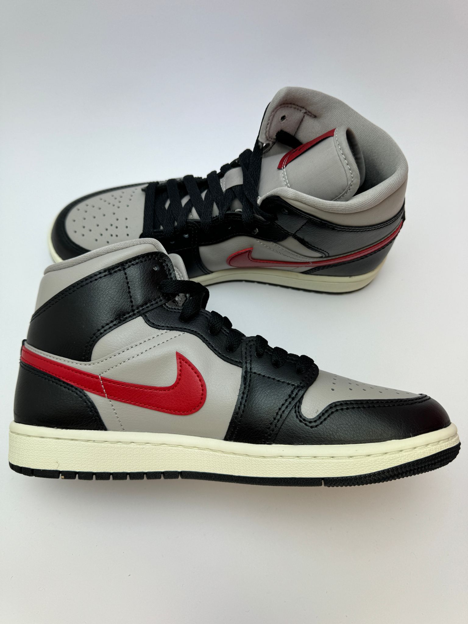 Jordan 1 Mid Black/College Grey–Gym Red – linke Außenseite mit Gym Red Akzenten am Swoosh und Fersen-Overlay