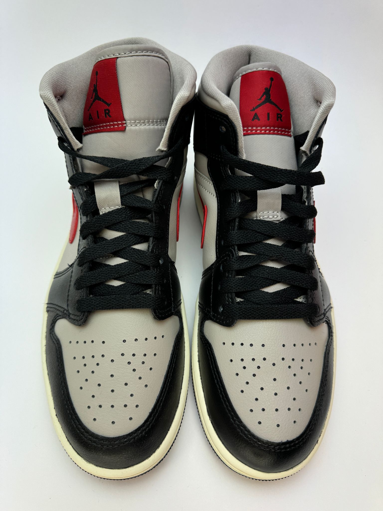 Detailansicht der Zunge – Jordan 1 Mid Black/College Grey–Gym Red mit gewebtem Jumpman‑Label und rotem Branding