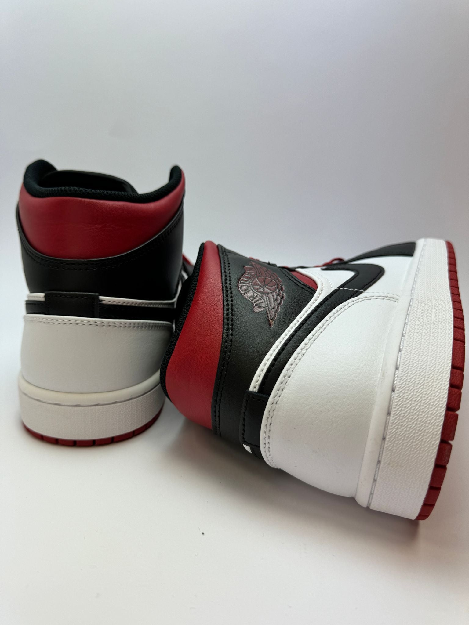 Rückansicht des Sneakers – Jordan 1 Mid Gym Red Black Toe mit gepolstertem Heel-Tab und Nike-Wings-Logo