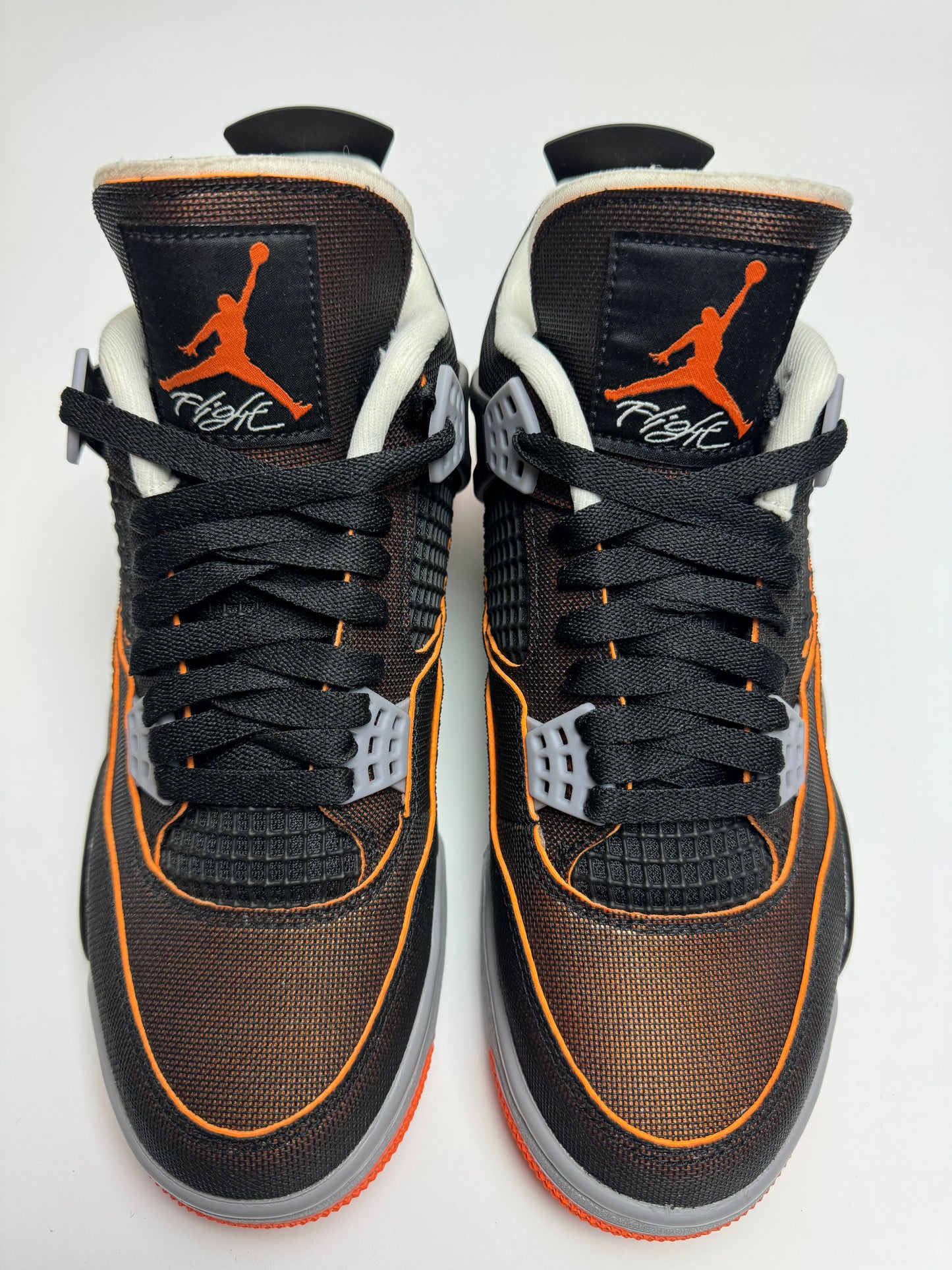 Detail der Tongue – grob geschnittener Zungenrand mit sichtbarem Foam, Jumpman Logo in Orange auf schwarzem Mesh