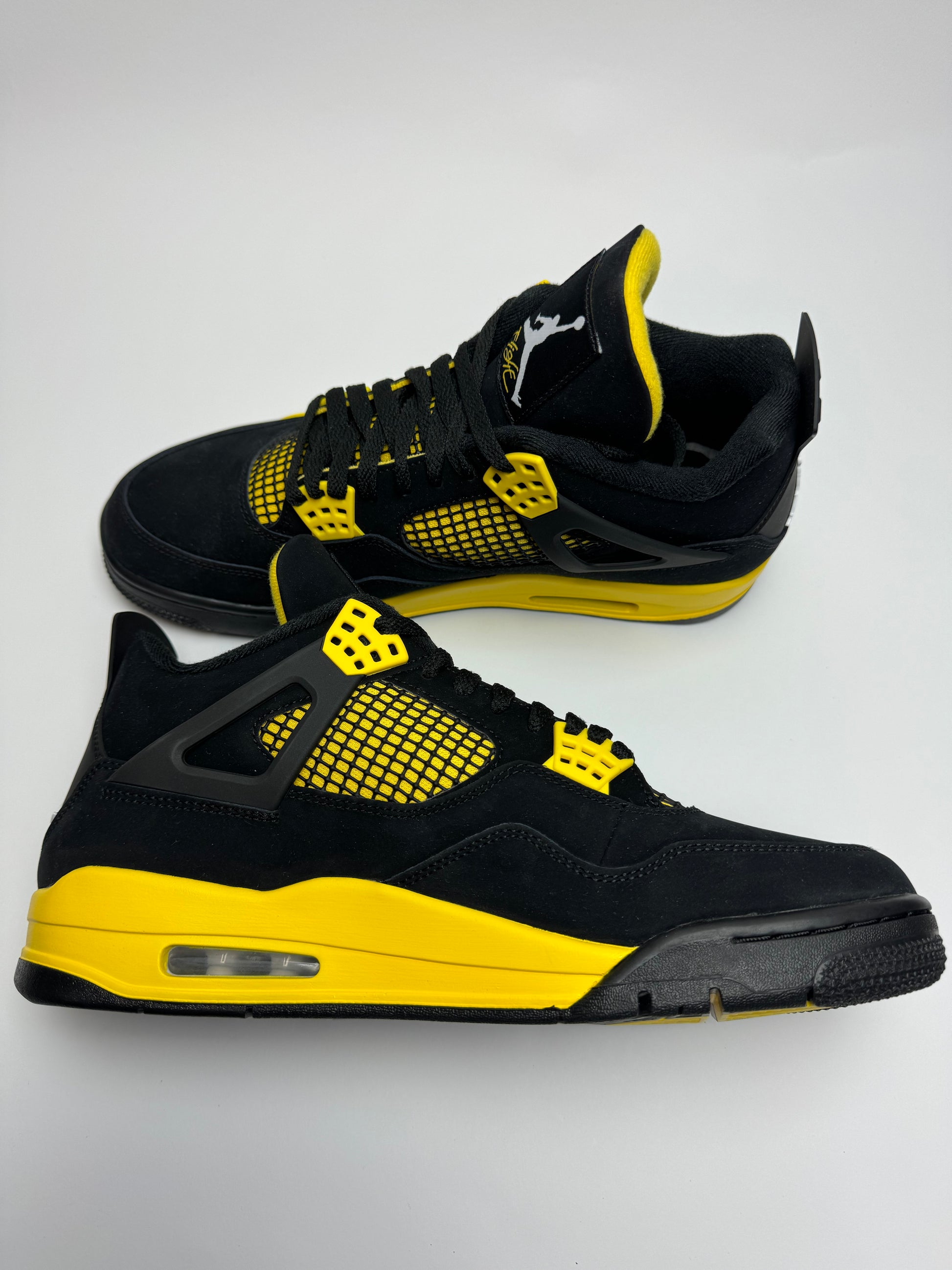 Air Jordan 4 Thunder – linke Außenseite mit komplett schwarzem Upper, gelber Air‑Midsole-Anmutung und sauberem Swoosh
