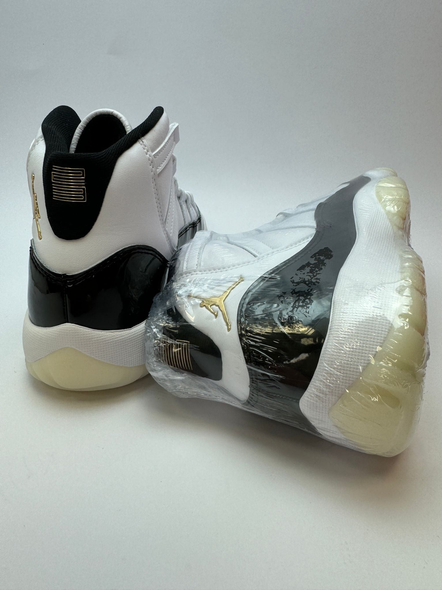 Rückansicht des Sneakers – Air Jordan 11 Gratitude mit geprägter ‚23‘ auf der Ferse und goldener Branding-Note