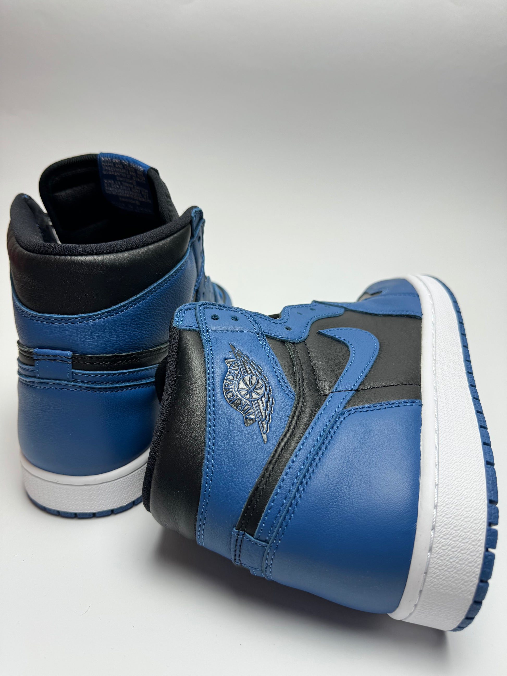 Rückansicht des Sneakers – Air Jordan 1 High Dark Marina Blue mit gepolstertem Heel‑Tab und Wings-Logo in Schwarz