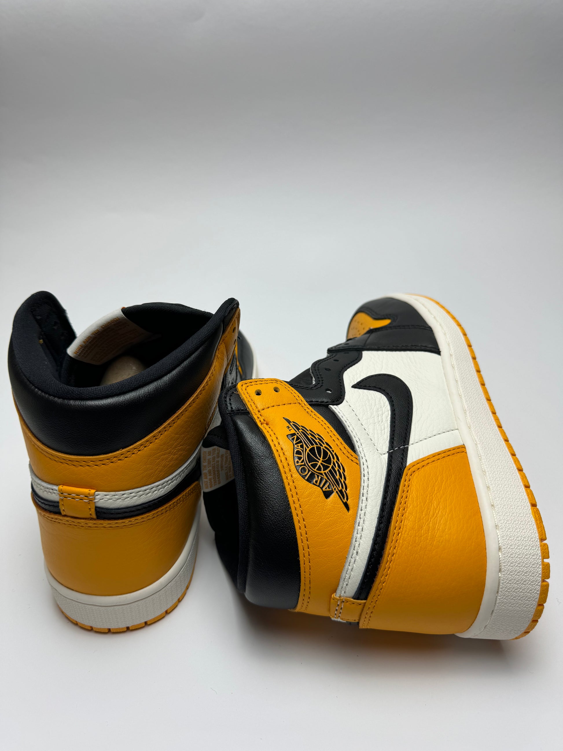 Rückansicht des High OG – NIKE AIR Branding in Yellow auf schwarzem Leder‑Heel, scharfem Schnitt