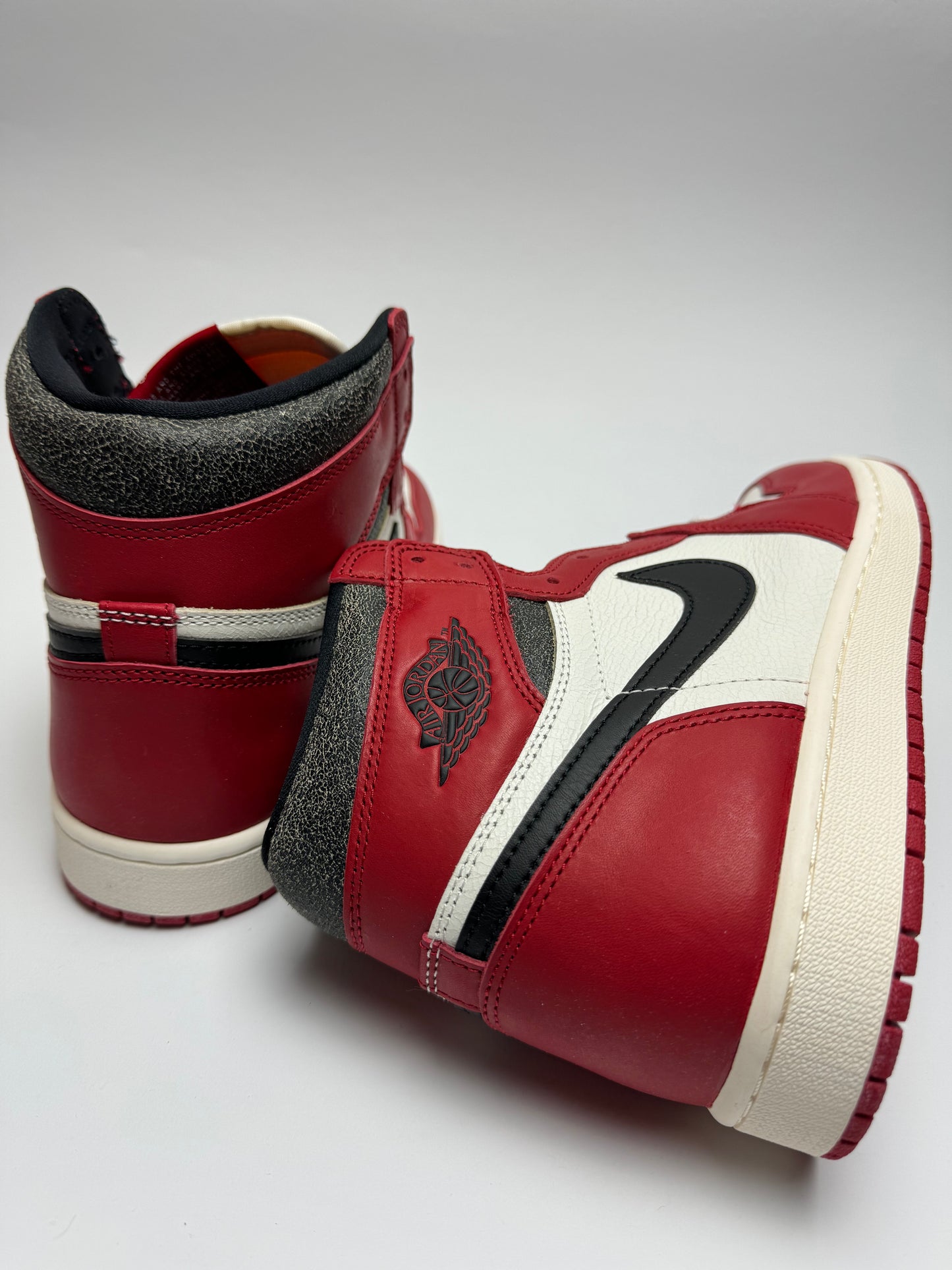 Rückansicht des Sneakers – Lost & Found mit Wings-Logo auf der Ferse und oxidierter vintage‑rot-gelb Verfärbung
