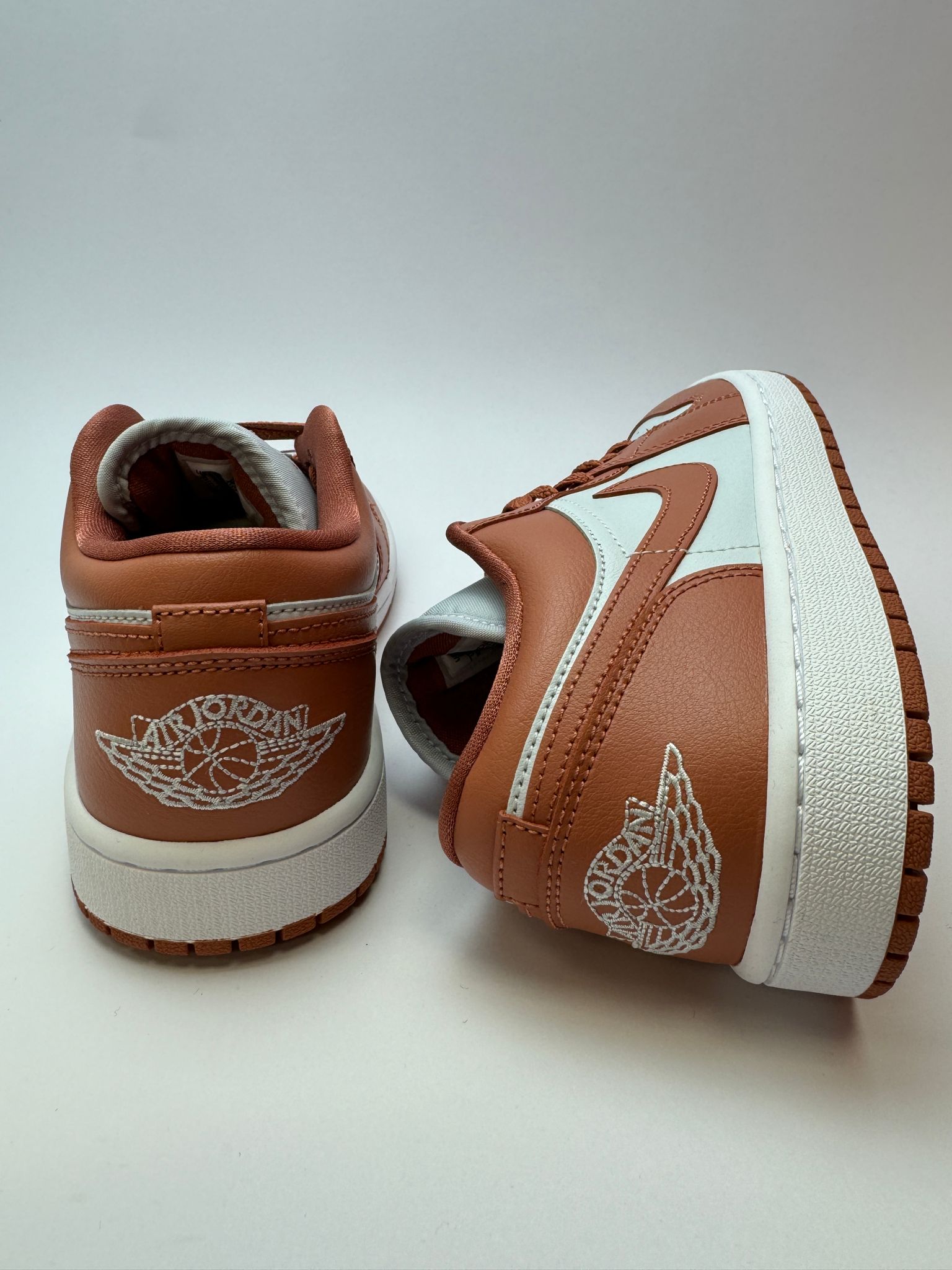Rückansicht des Sneakers – Jordan 1 Low Sky J Orange mit weißem Heel-Tab und silber‑weißem Wings‑Logo