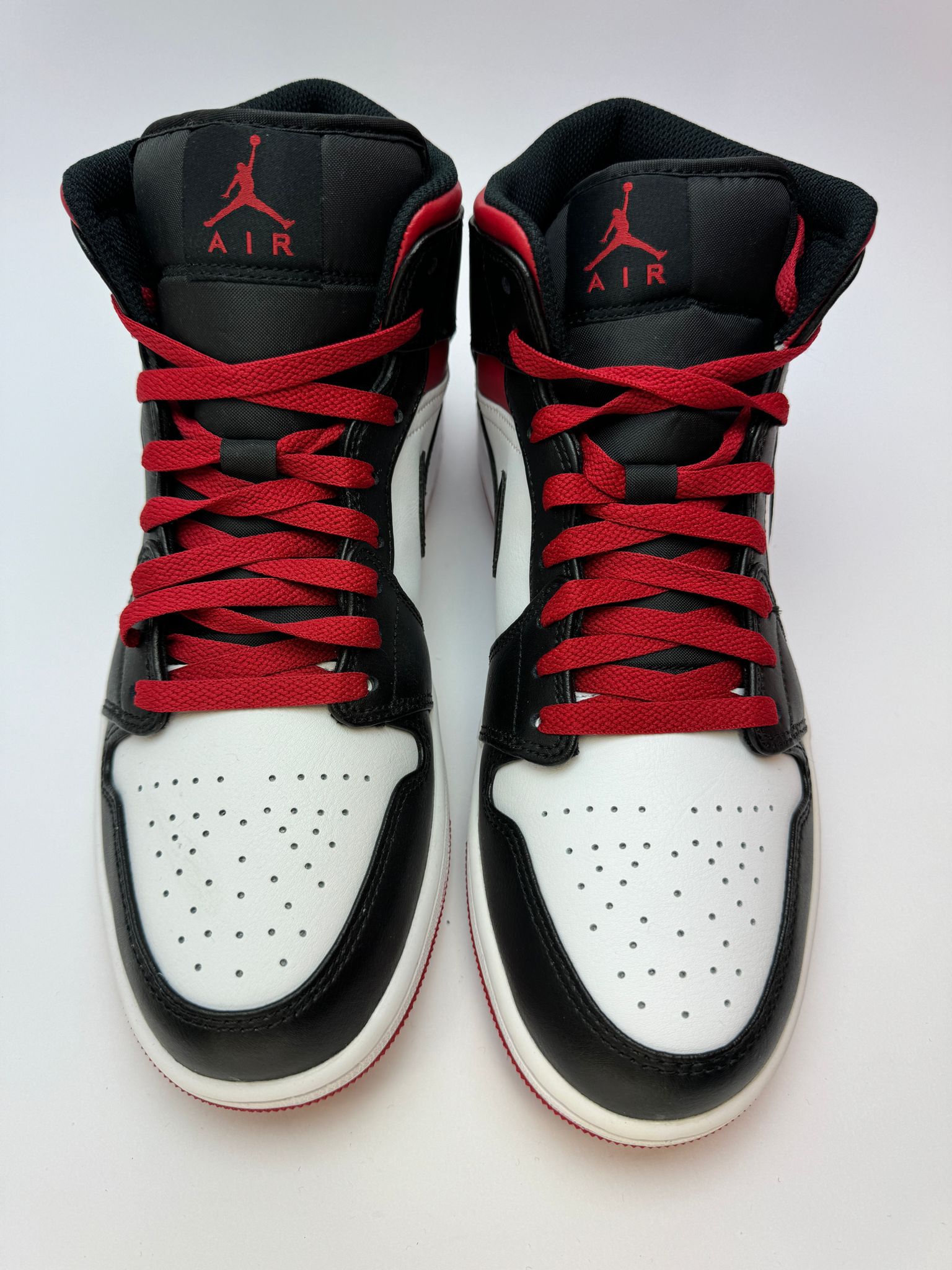 Detailansicht der Zunge – Jordan 1 Mid Gym Red Black Toe mit gewebtem Jumpman‑Label und rotem Branding