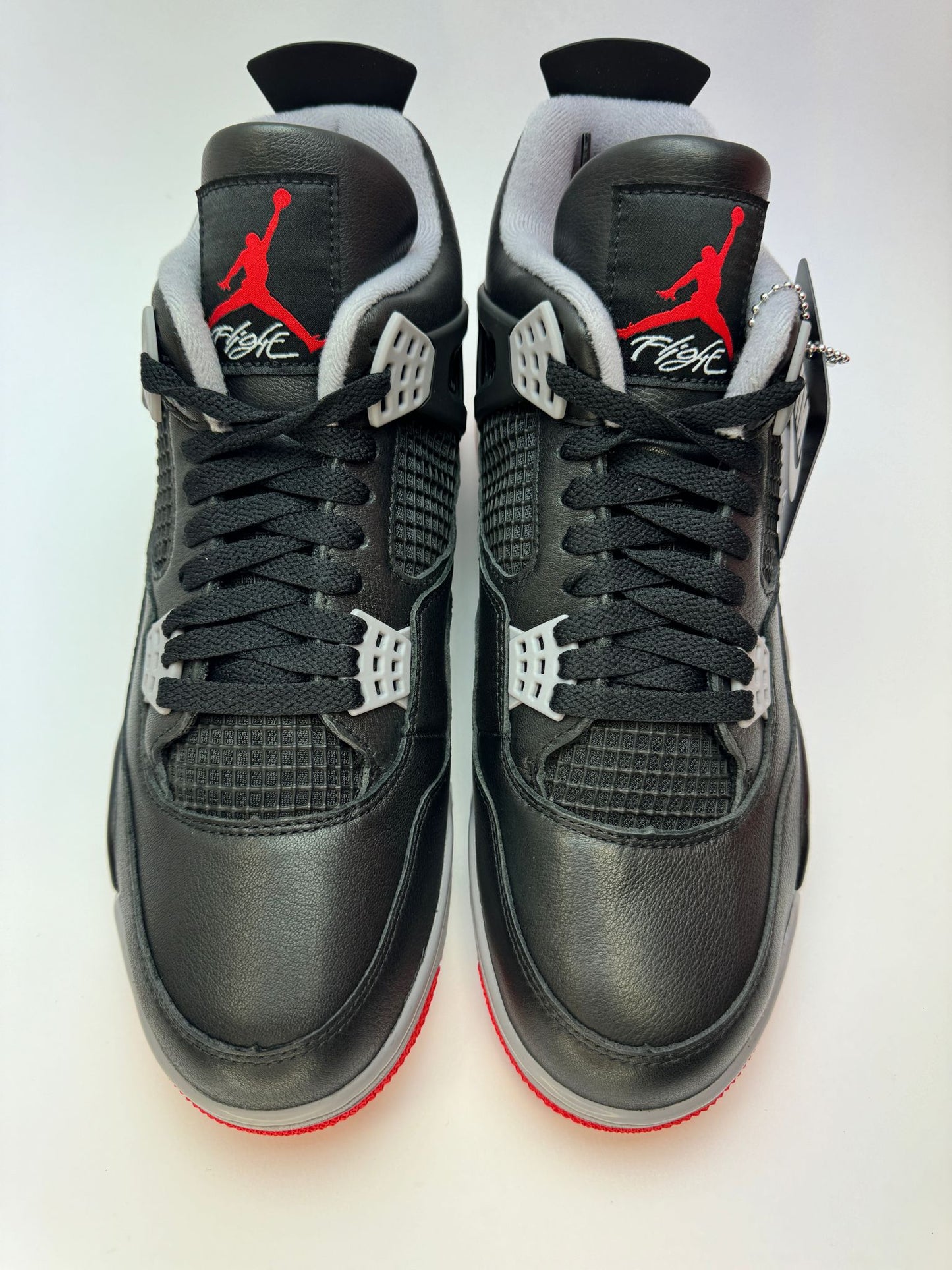 Rückansicht des Sneakers – Air Jordan 4 Retro Bred Reimagined mit vergrößertem Gummietikett an der Ferse