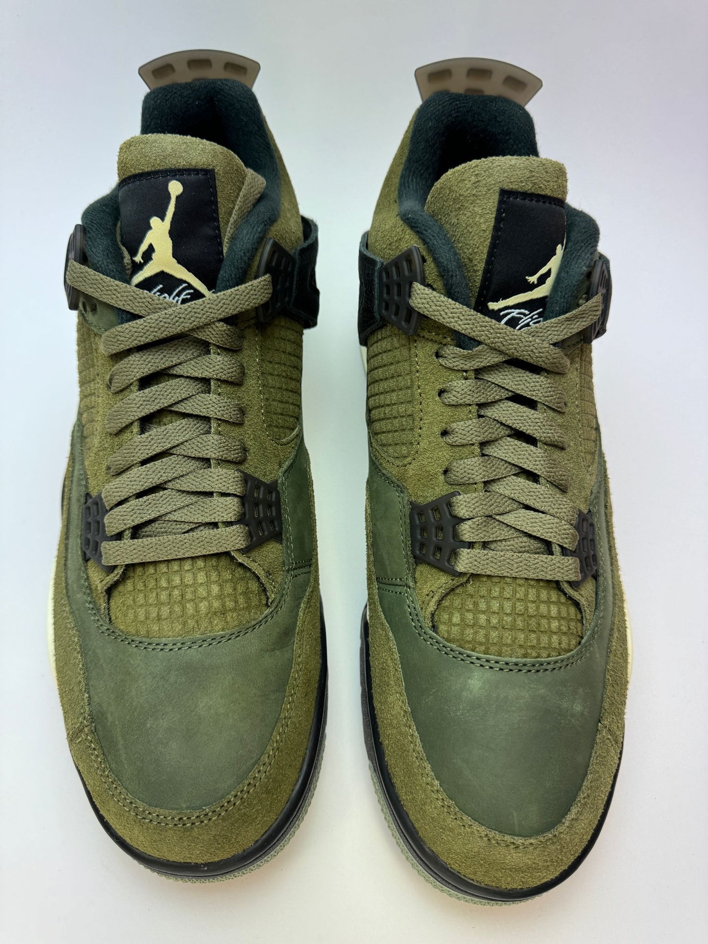 Detailansicht der Zunge – Air Jordan 4 Craft Medium Olive mit gewebtem Flight-Label und geprägtem Jumpman