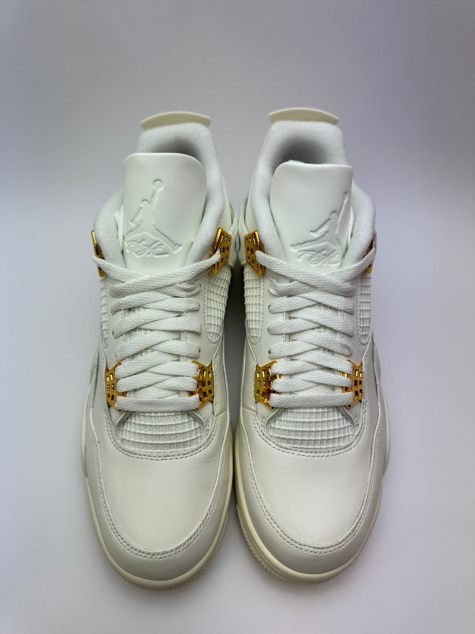 Detailansicht der Zunge – Air Jordan 4 Retro Metallic Gold mit Flight-Logo und glänzenden Metallic-Akzenten