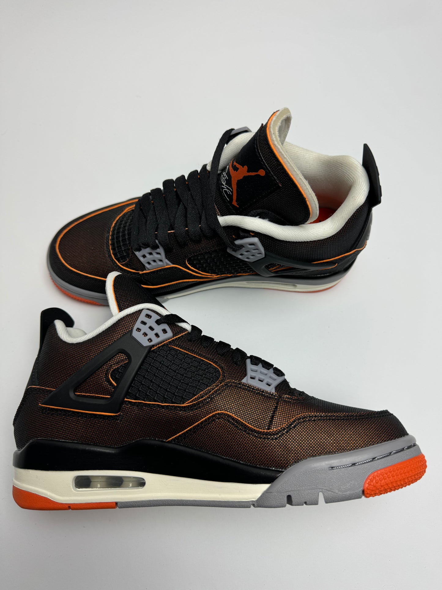 Air Jordan 4 Starfish – linke Außenseite mit schwarzem Netzgewebe und orangefarbenem Sternfish‑Farbakzent am TPU-Flügel