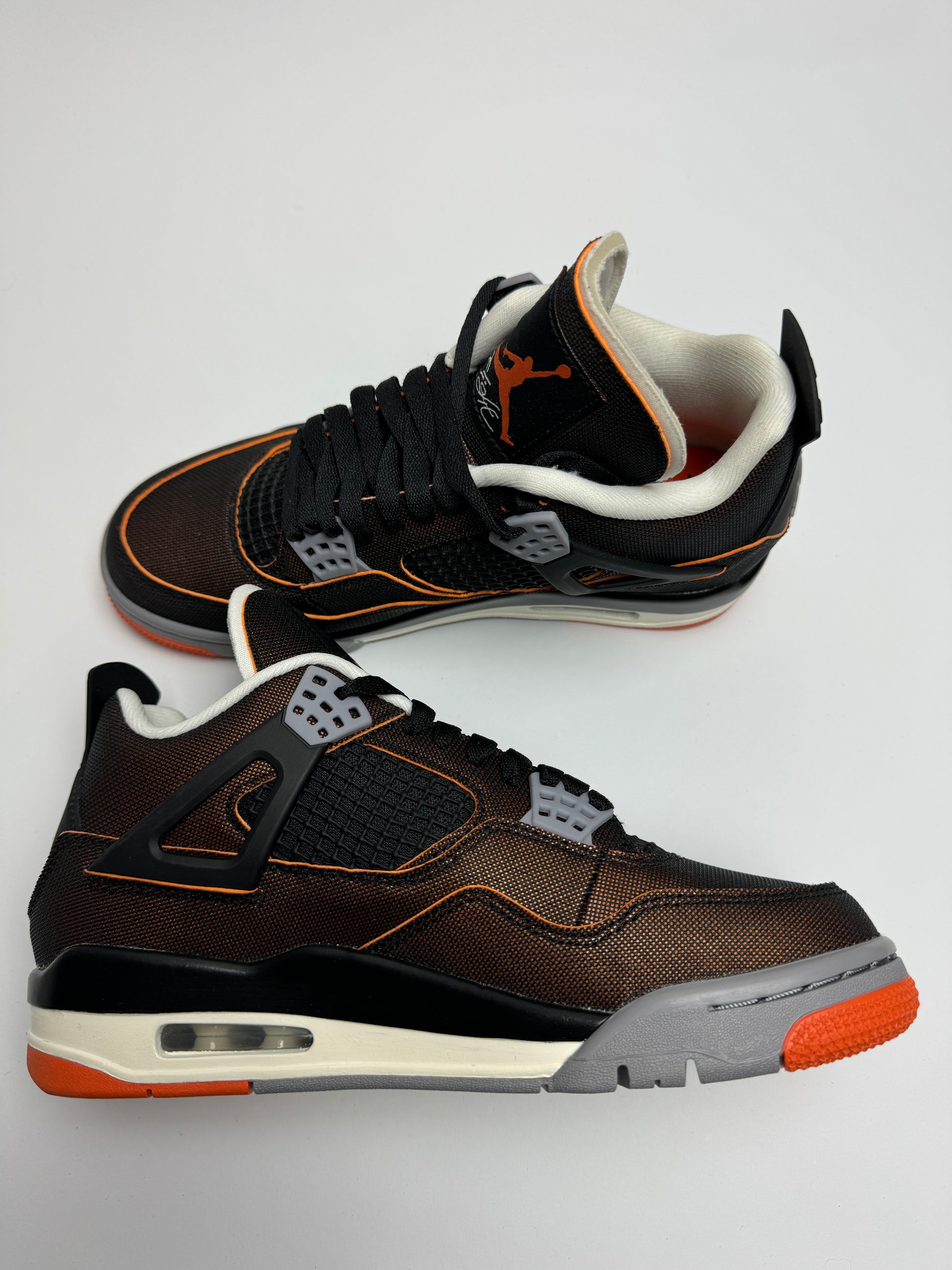 Air Jordan 4 Starfish – linke Außenseite mit schwarzem Netzgewebe und orangefarbenem Sternfish‑Farbakzent am TPU-Flügel