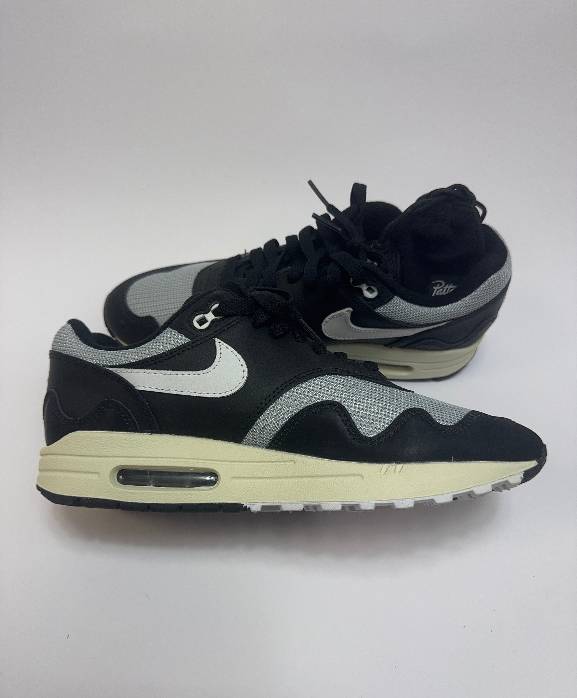 Nike Air Max 1 Patta Waves Black linke Ansicht mit Coconut Milk Midsole und Mini-Swoosh auf dem Mudguard
