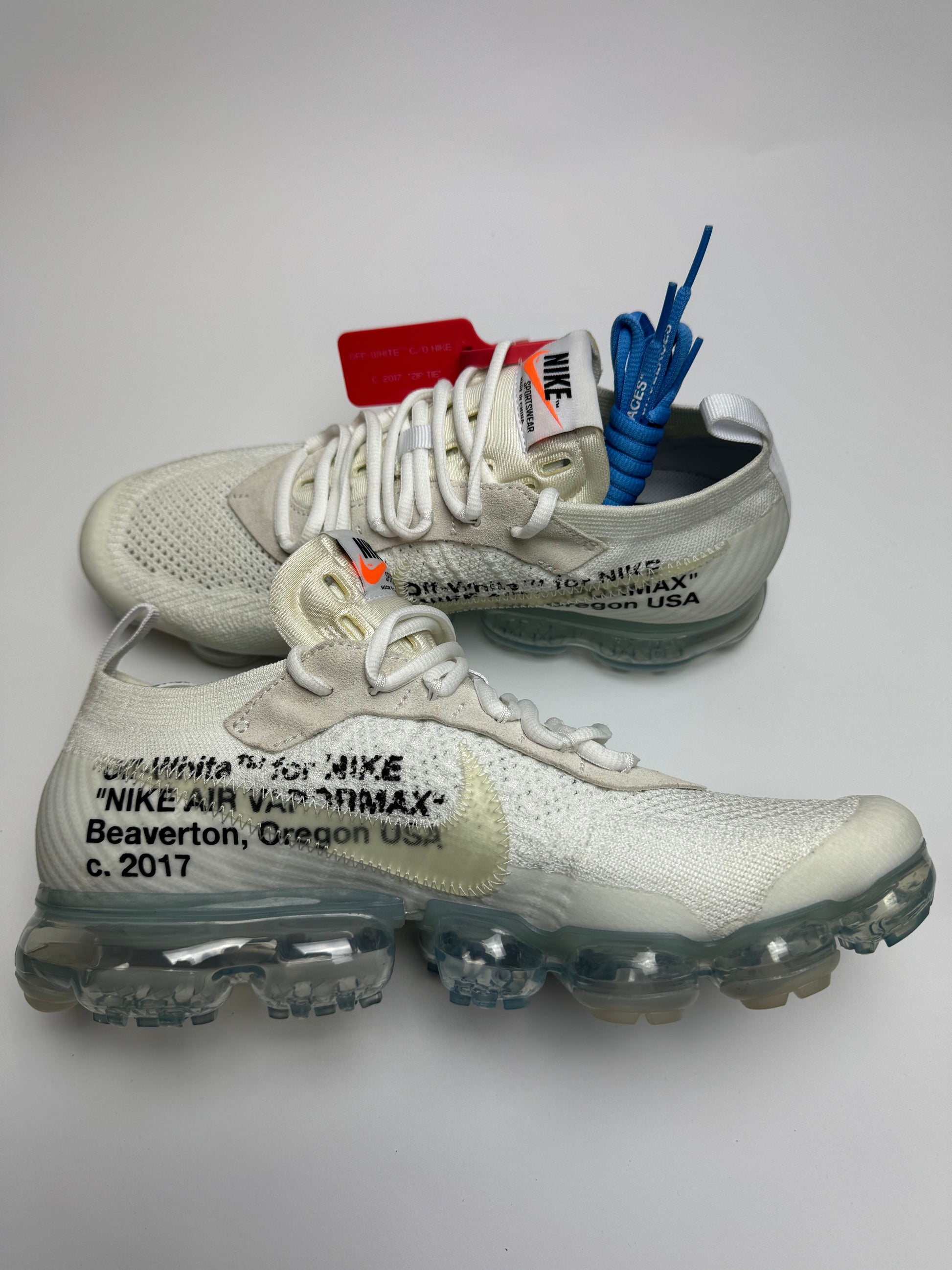 Off‑White VaporMax White – linke Außenseite mit klarer VaporMax-Luftsohle und orangefarbener Zip‑Tie an der Halslasche
