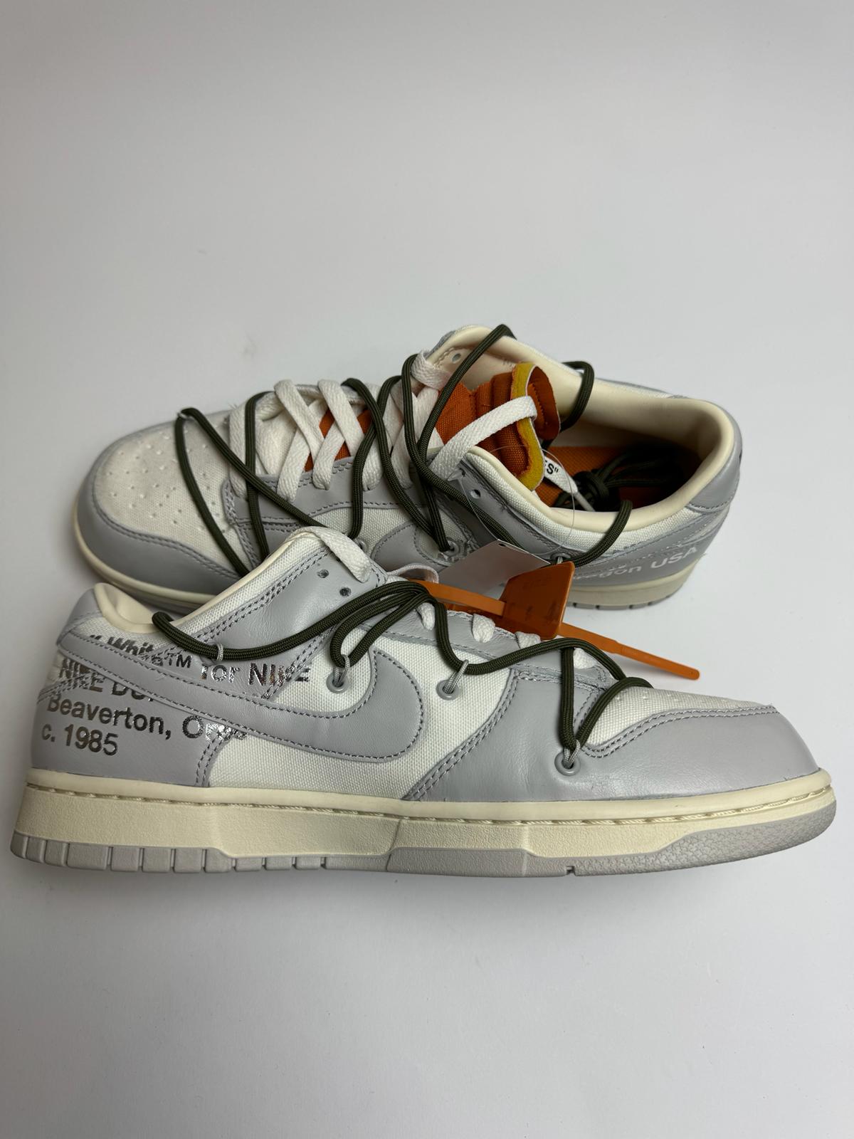 Off-White Nike Dunk Low Lot 22 – linke Außenseite mit grauem Swoosh und typischem Helvetica-Branding unter dem Logo