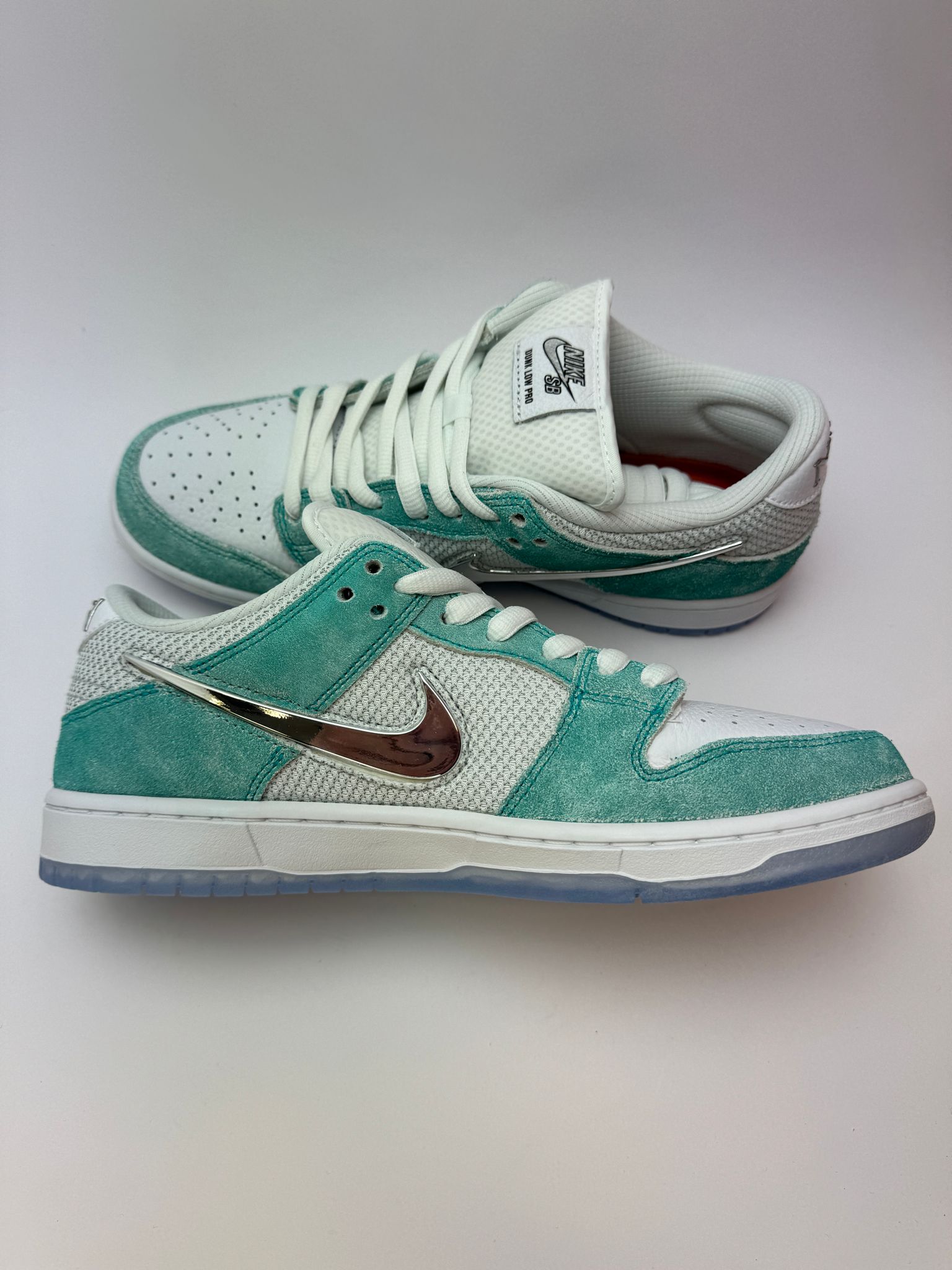 Nike SB Dunk Low April Skateboards – linke Außenseite mit silbernem, geformtem Swoosh und April-Branding an der Ferse