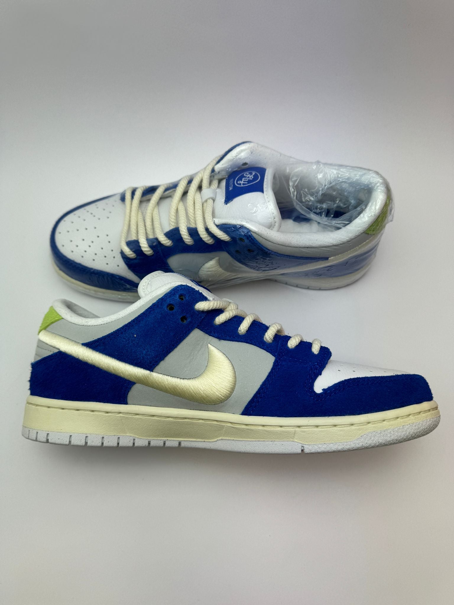 Nike SB Dunk Low Pro x Fly Streetwear 'Gardenia' – Detailaufnahme der limegrünen Zunge mit Fly Streetwear-Branding