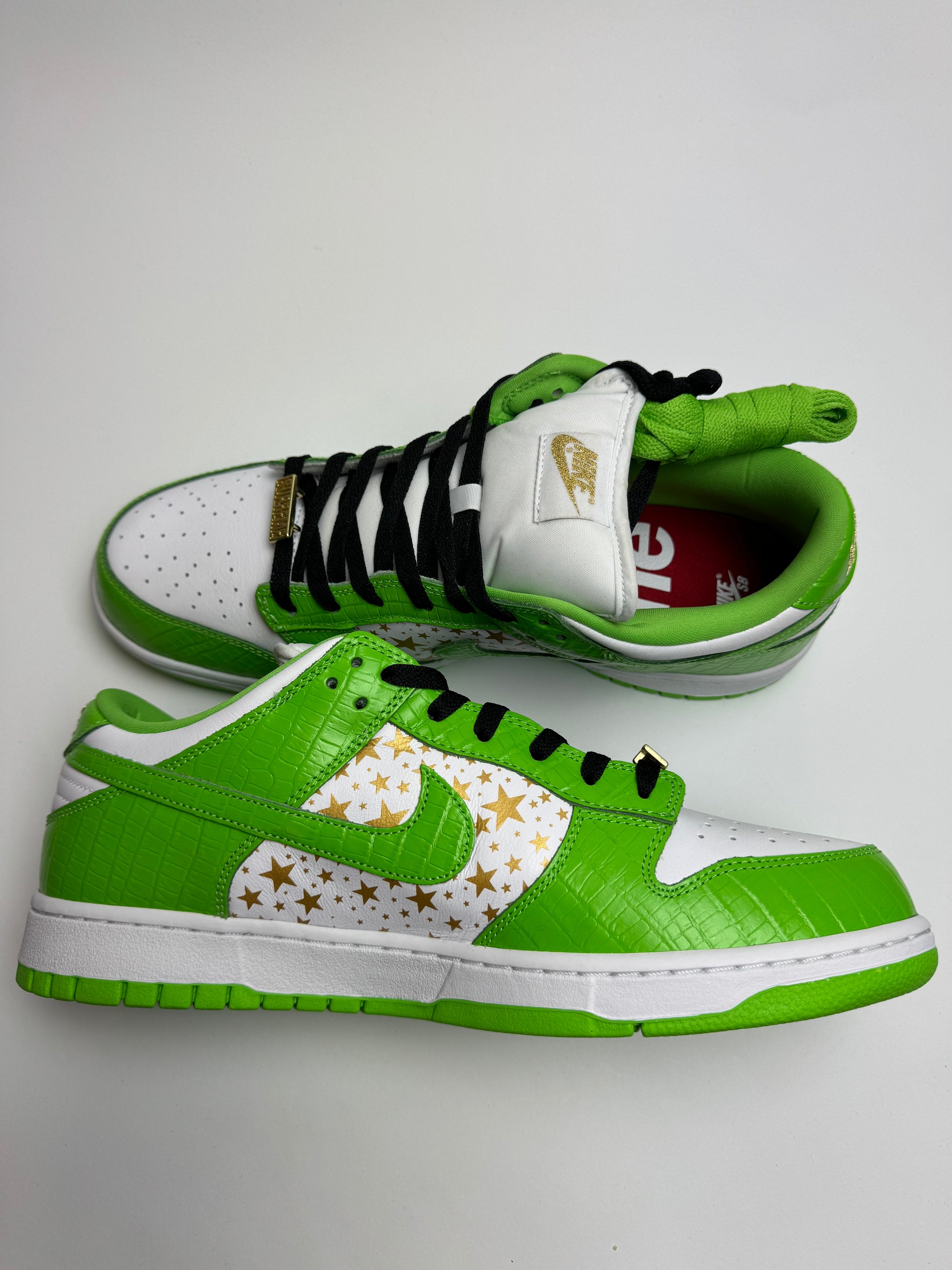 Nike SB Dunk Low Supreme Mean Green – linke Außenseite mit grüner Swoosh-Ziehung und goldenen Sternen auf dem Quarter-Panel