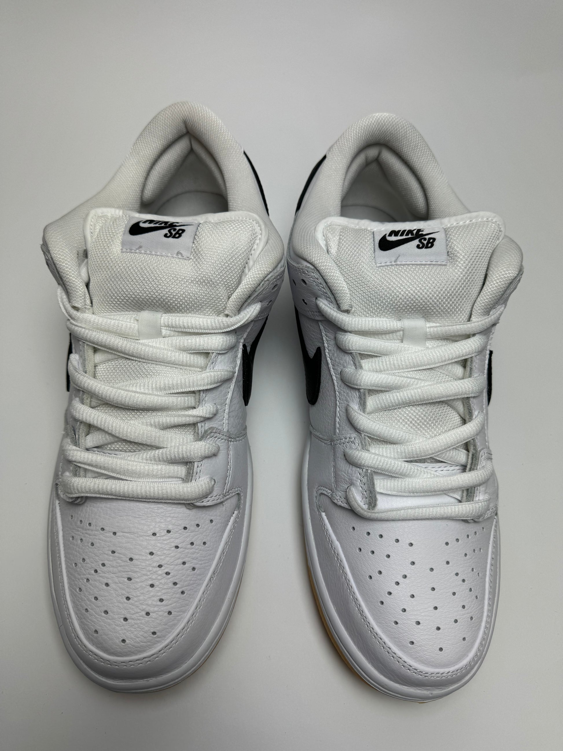 Detailaufnahme der Rückseite – minimalistisches Heel-Branding auf weißem Leder mit tonaler Stickerei