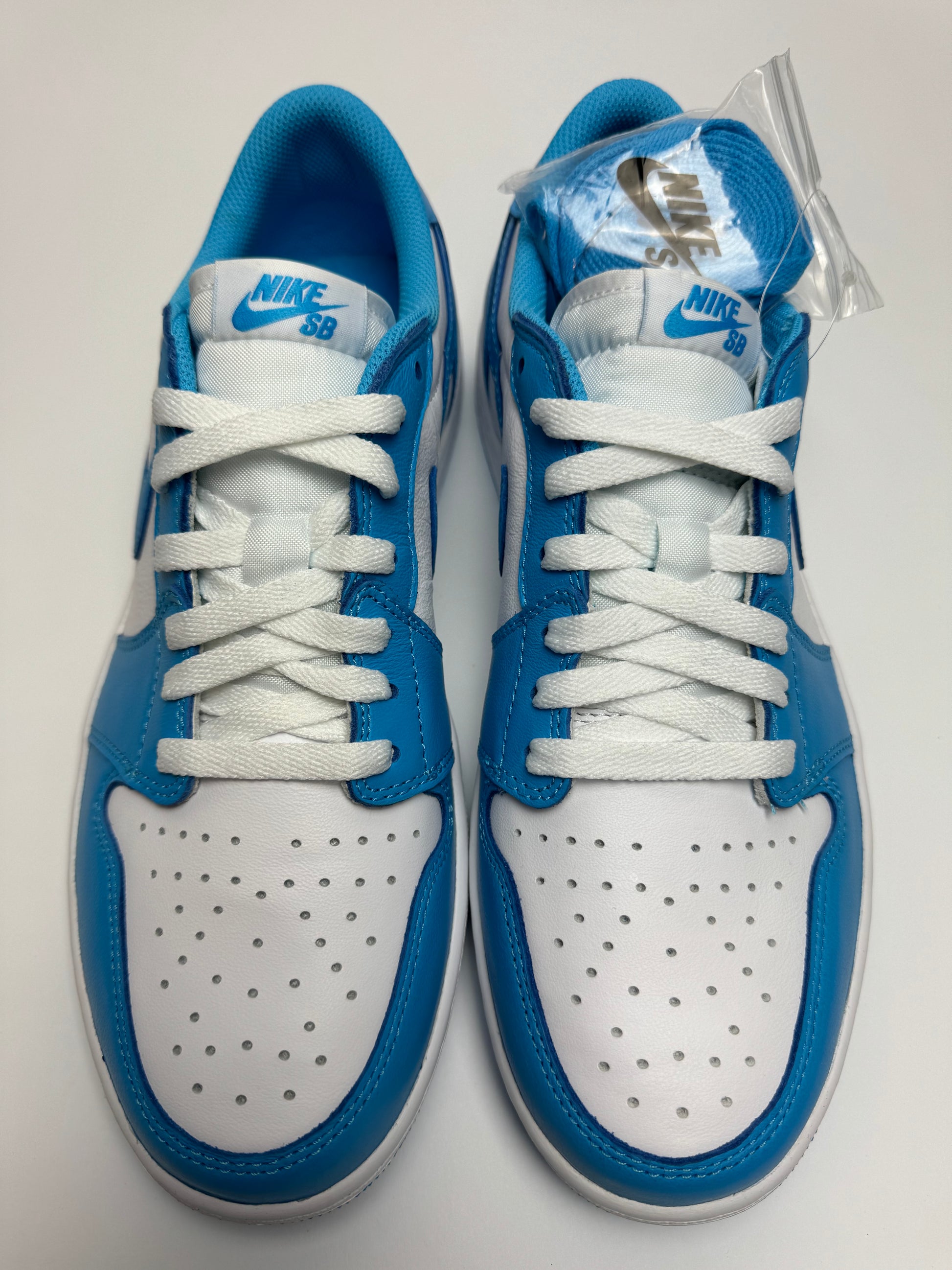 Detailansicht der Zunge – Nike SB × AJ1 Low UNC mit blauem Nike SB-Label und gepolstertem Collar