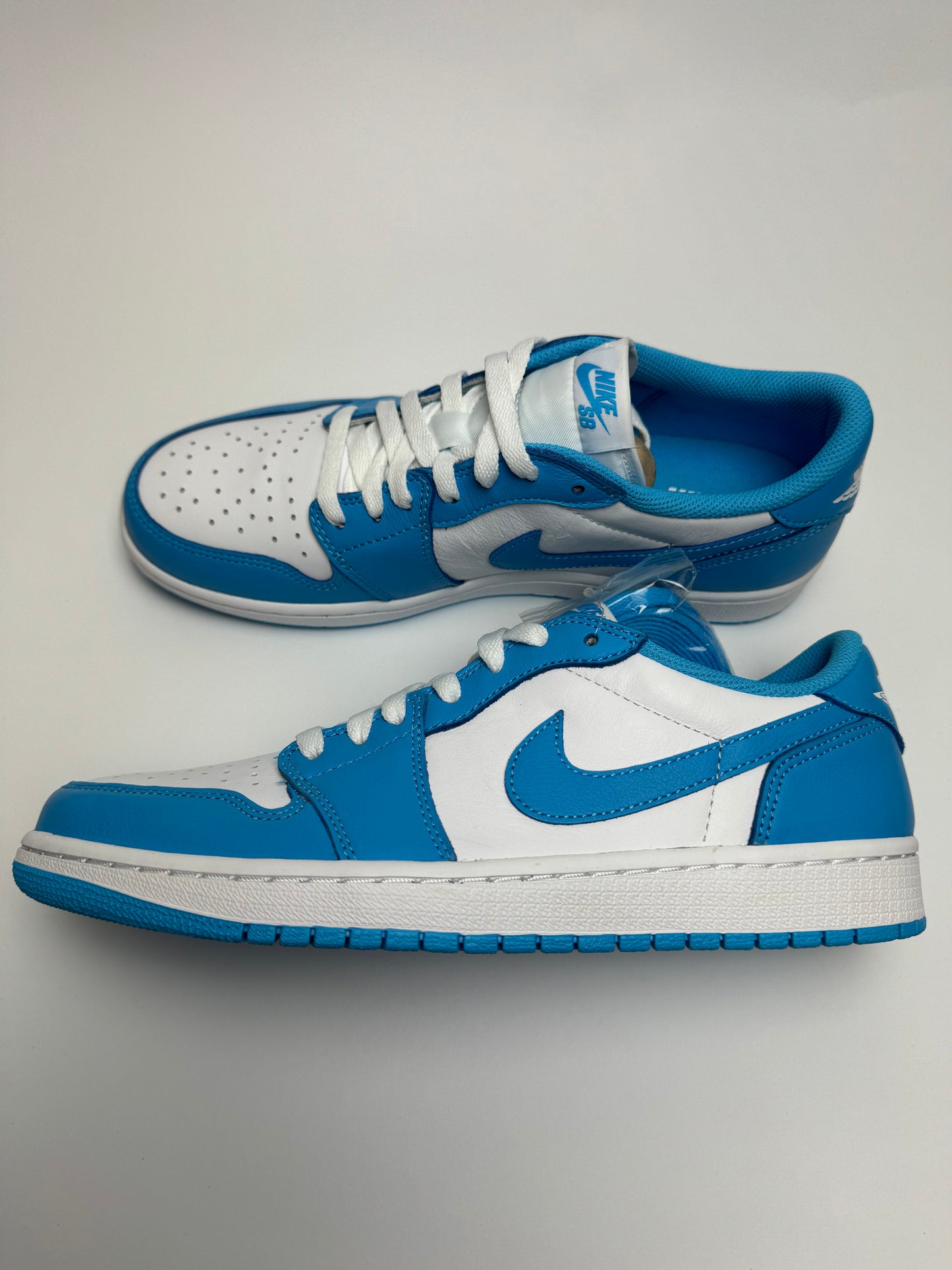 Nike SB × AJ1 Low UNC – rechte Seitenansicht mit weißem Leder-Upper und dunkelblauen UNC-Overlays