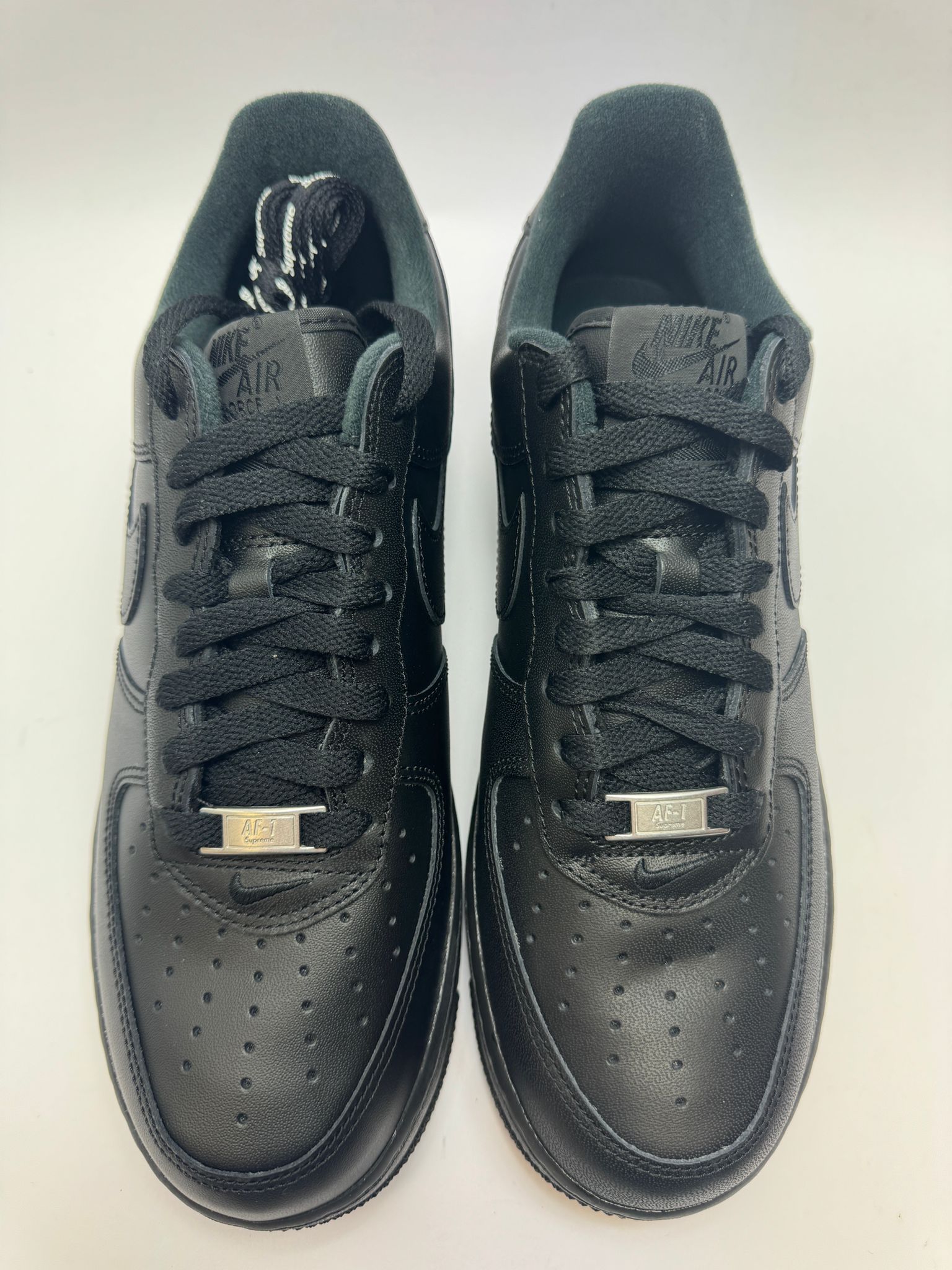 Detailansicht der Zunge – Nike Air Force 1 Low Supreme Black mit Supreme Logo