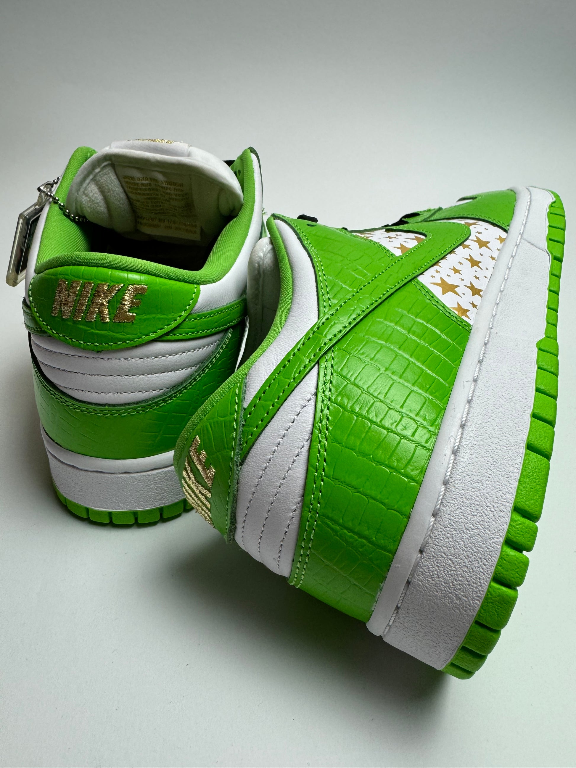 Rückansicht des Sneakers – Nike SB Dunk Low Supreme Mean Green mit goldgesticktem NIKE‑Branding auf der Ferse