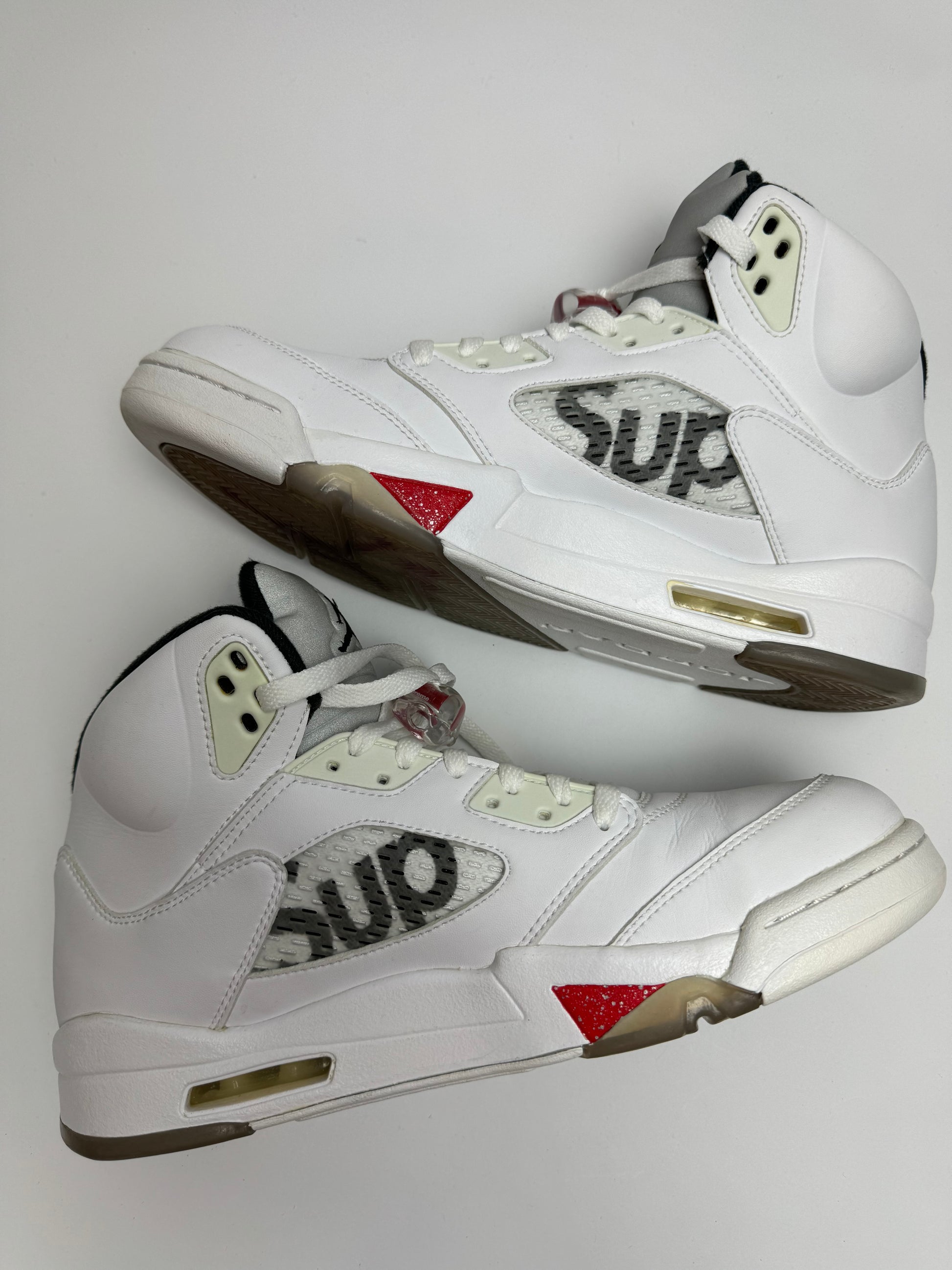 Air Jordan 5 Supreme White – linke Seitenansicht mit translucent Mesh, roten Shark‑Teeth-Details und Supreme‑Stickerei