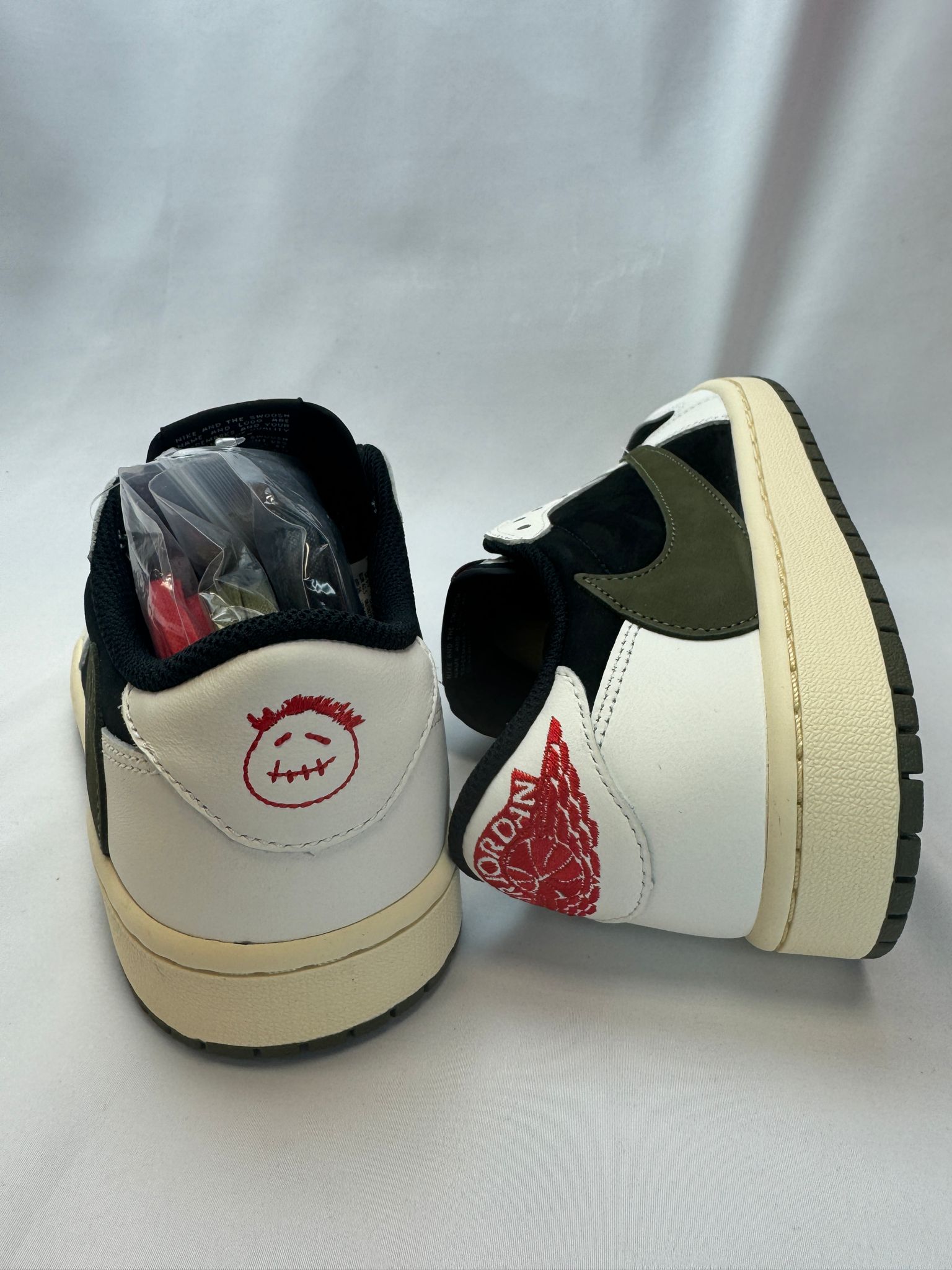 Rückansicht des Sneakers – gesticktes Cactus Jack-Logo auf der Ferse mit Olive-Gummi-Outsole