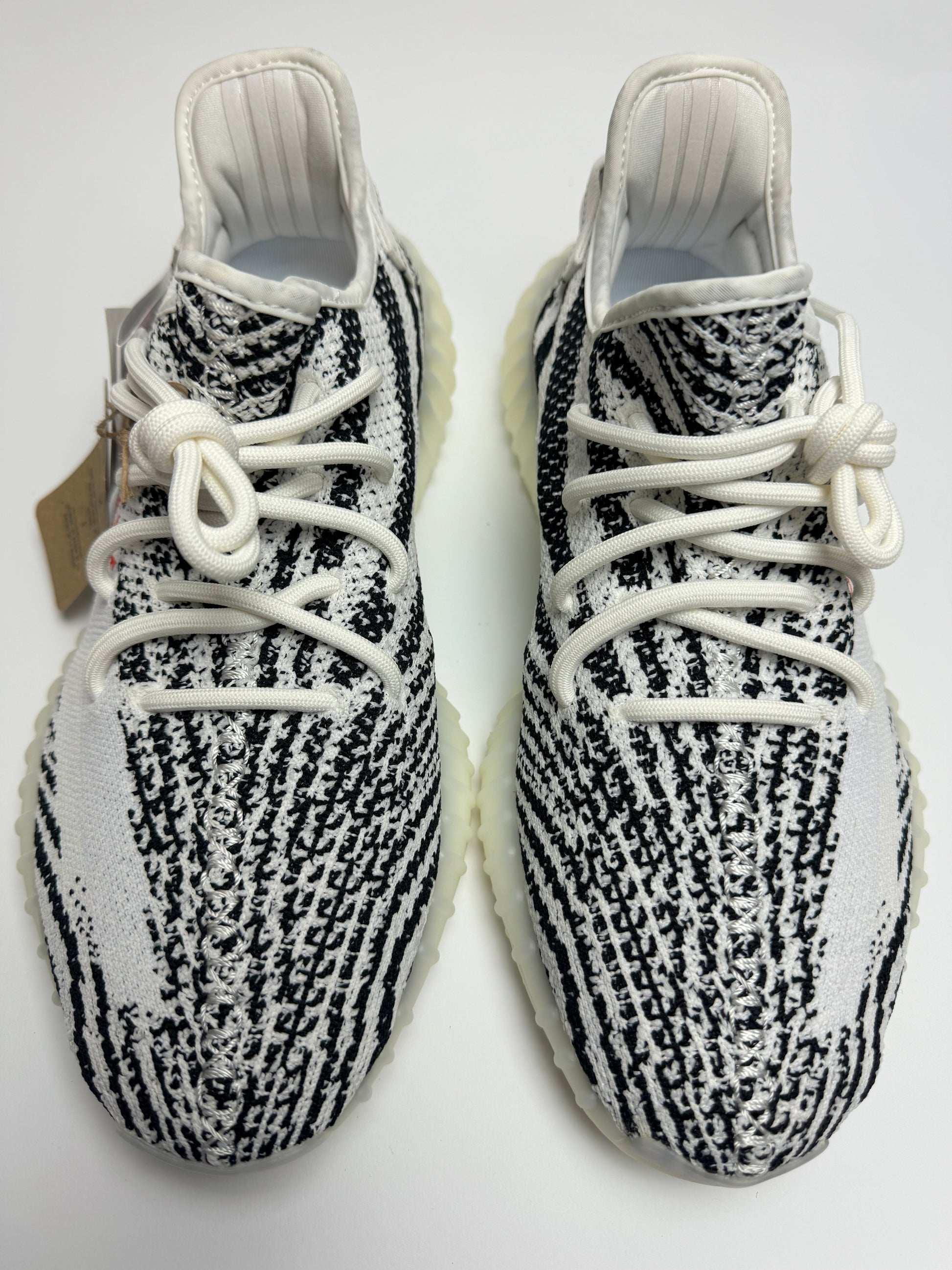 Detailansicht der Zunge – Yeezy Boost 350 V2 Zebra mit gesticktem Pull‑Tab und engmaschiger Primeknit-Struktur