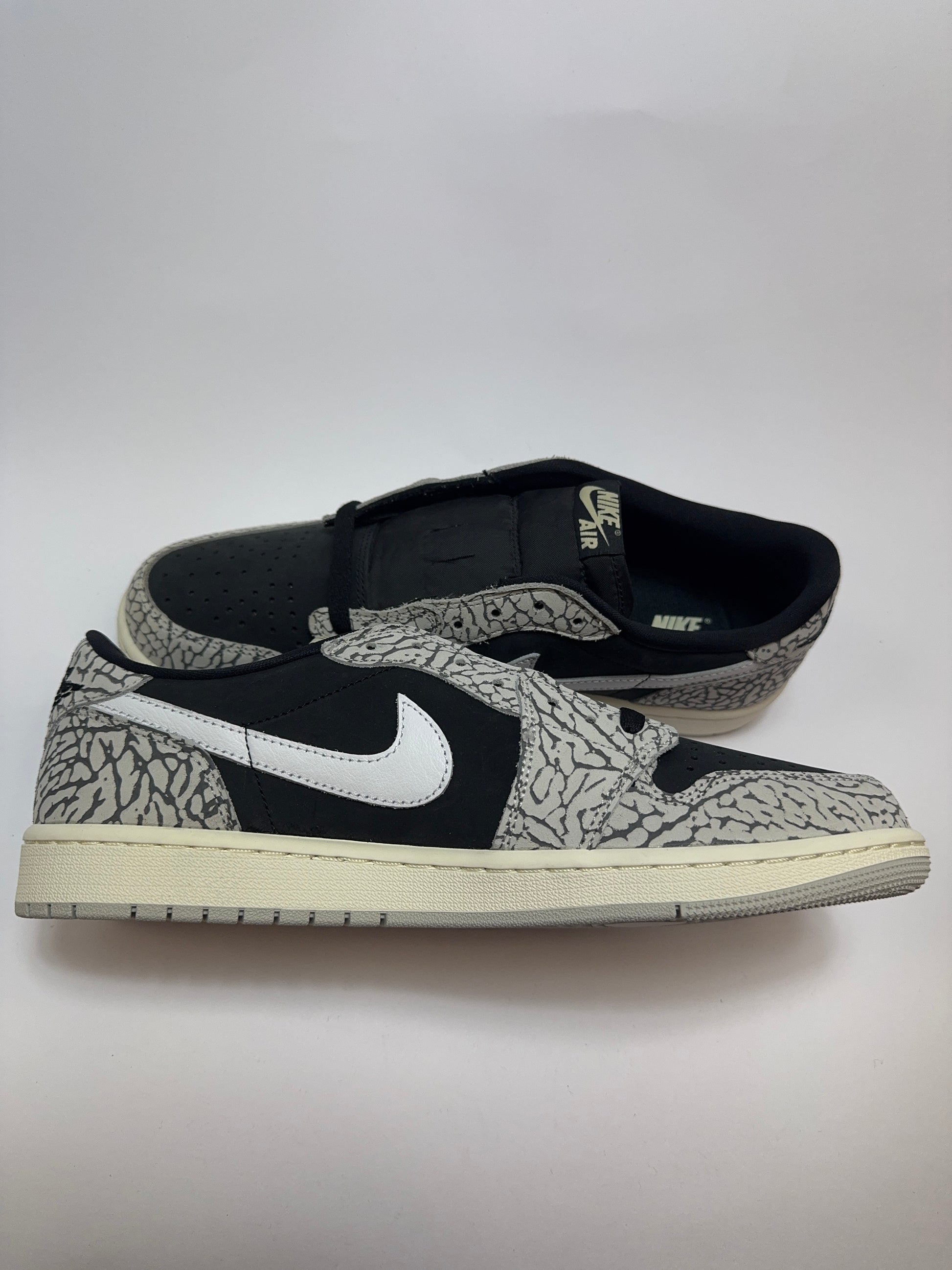 Air Jordan 1 Low Black Cement linke Ansicht mit Fire Red Jumpman auf der Zunge und kontrastierenden Details