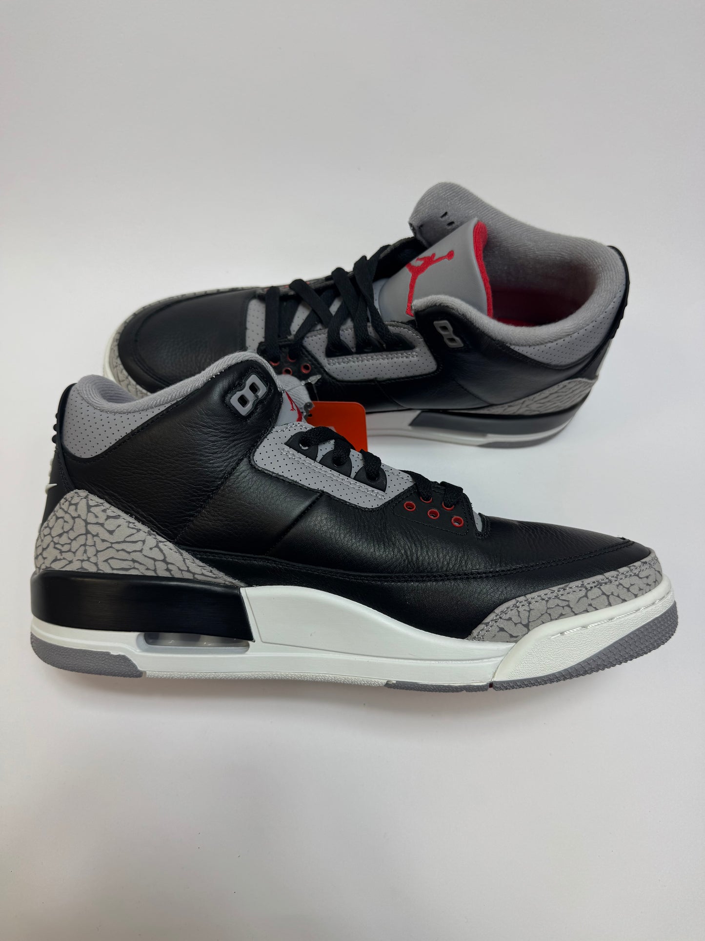 Air Jordan 3 Black Cement 2024 linke Ansicht mit Fire Red Jumpman auf der Zunge und Sail Midsole