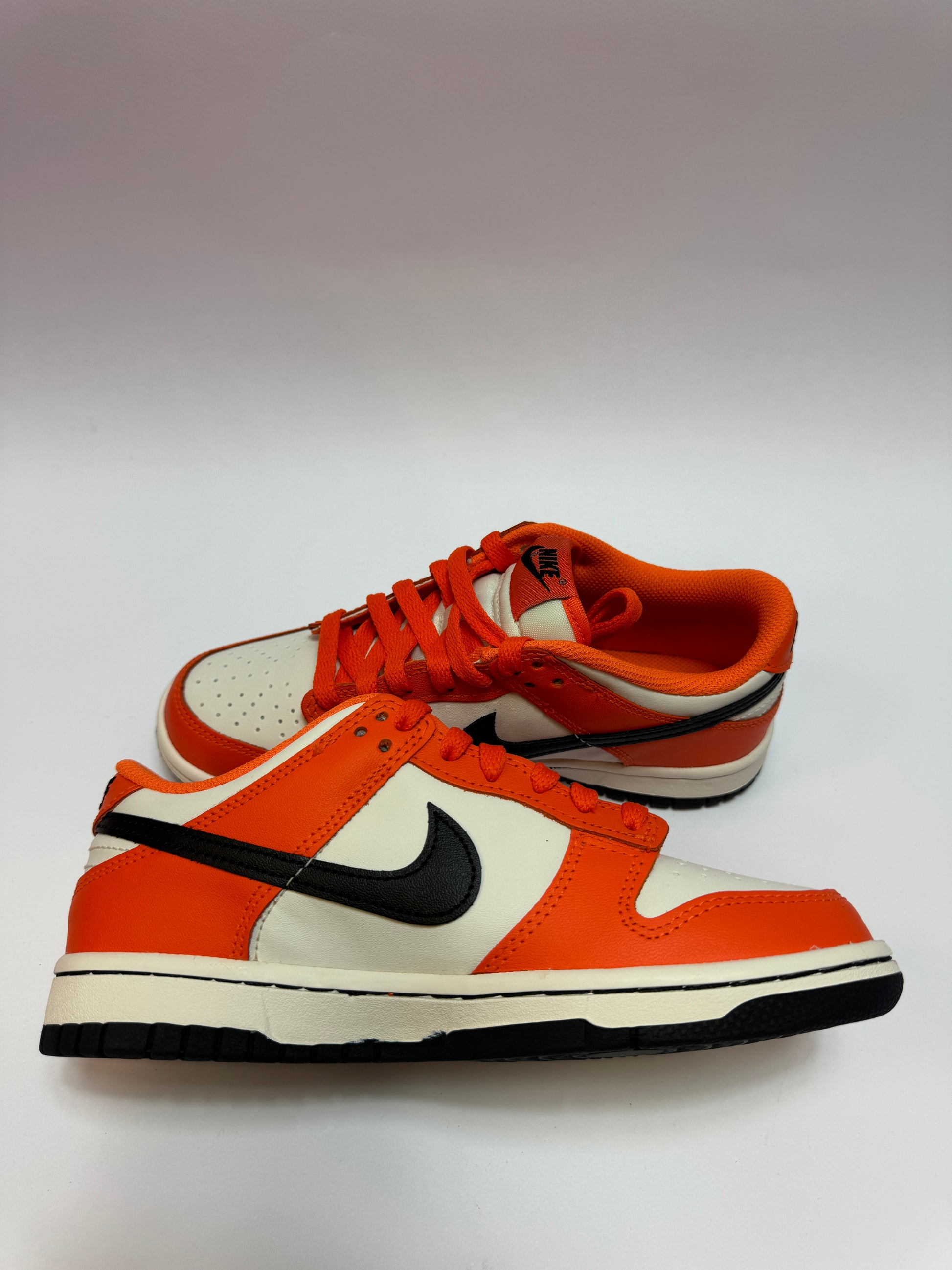 Nike Dunk Low Halloween 2022 GS linke Ansicht mit Safety Orange Overlays und Lederstruktur