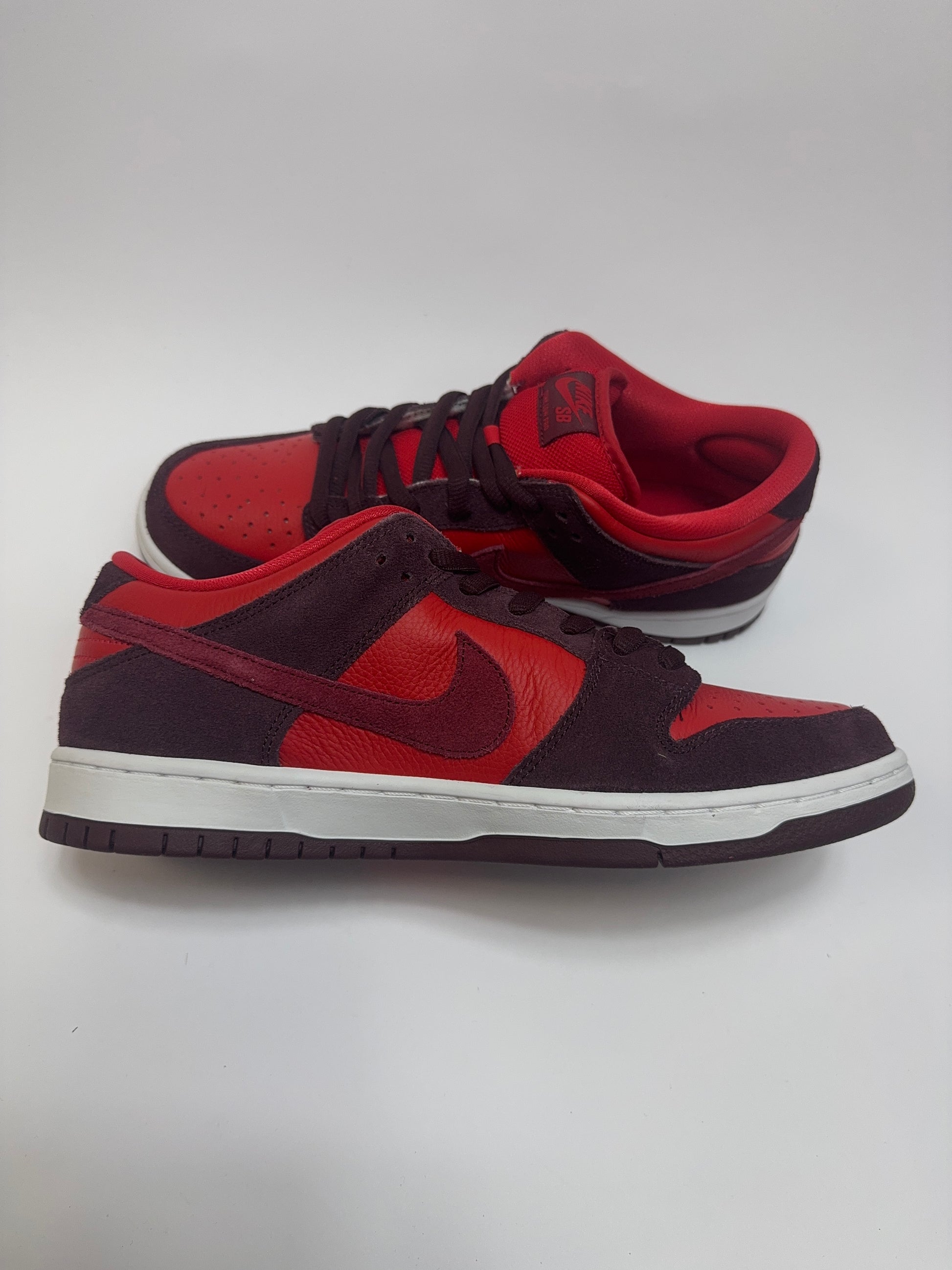 Nike SB Dunk Low Cherry linke Ansicht mit Burgundy Crush Panels, weißem Swoosh und strukturierter Lederbasis