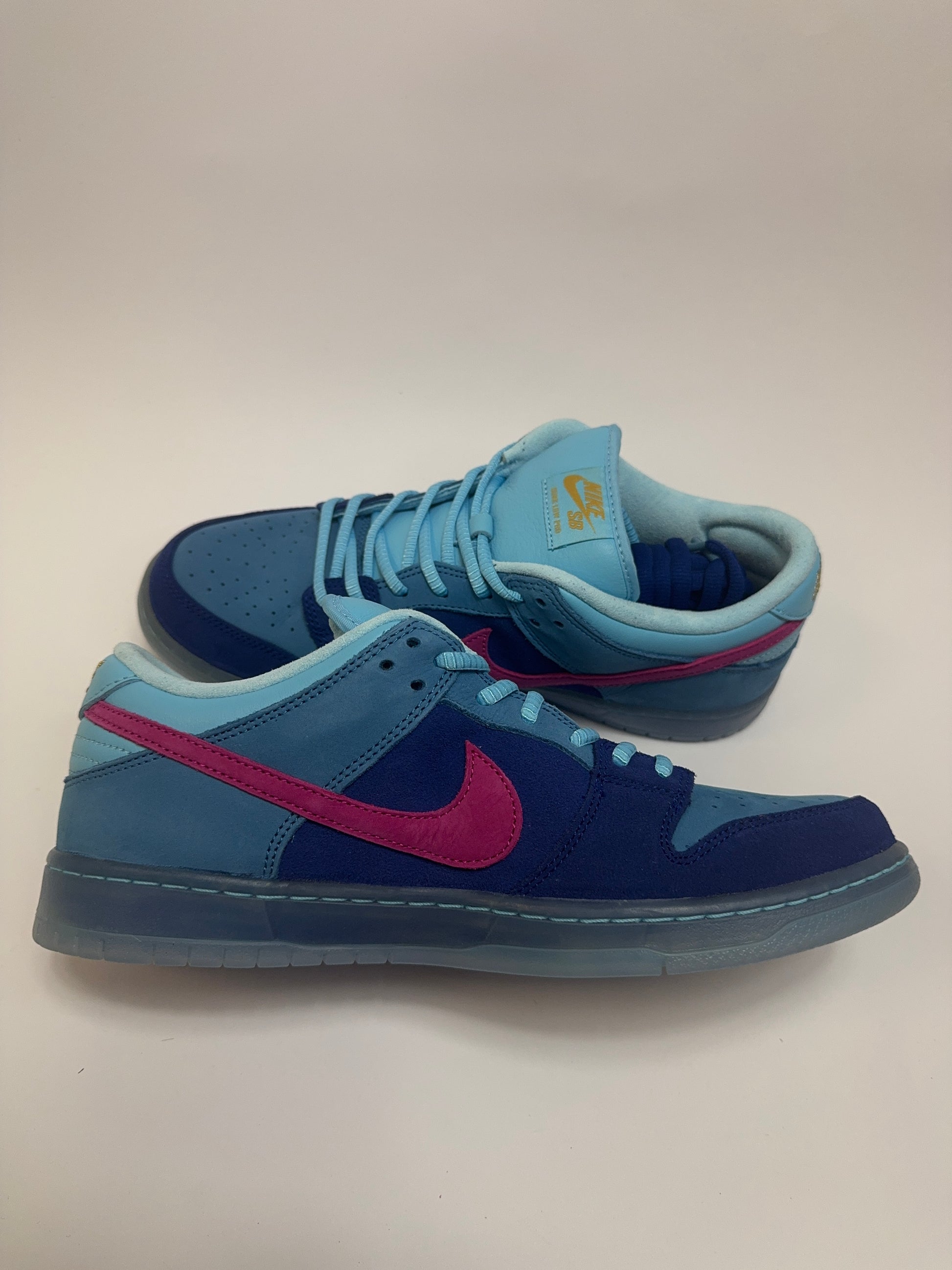 Nike SB Dunk Low Run The Jewels linke Ansicht mit Blue Chill Akzenten und goldfarbenem Branding an Ferse und Zunge