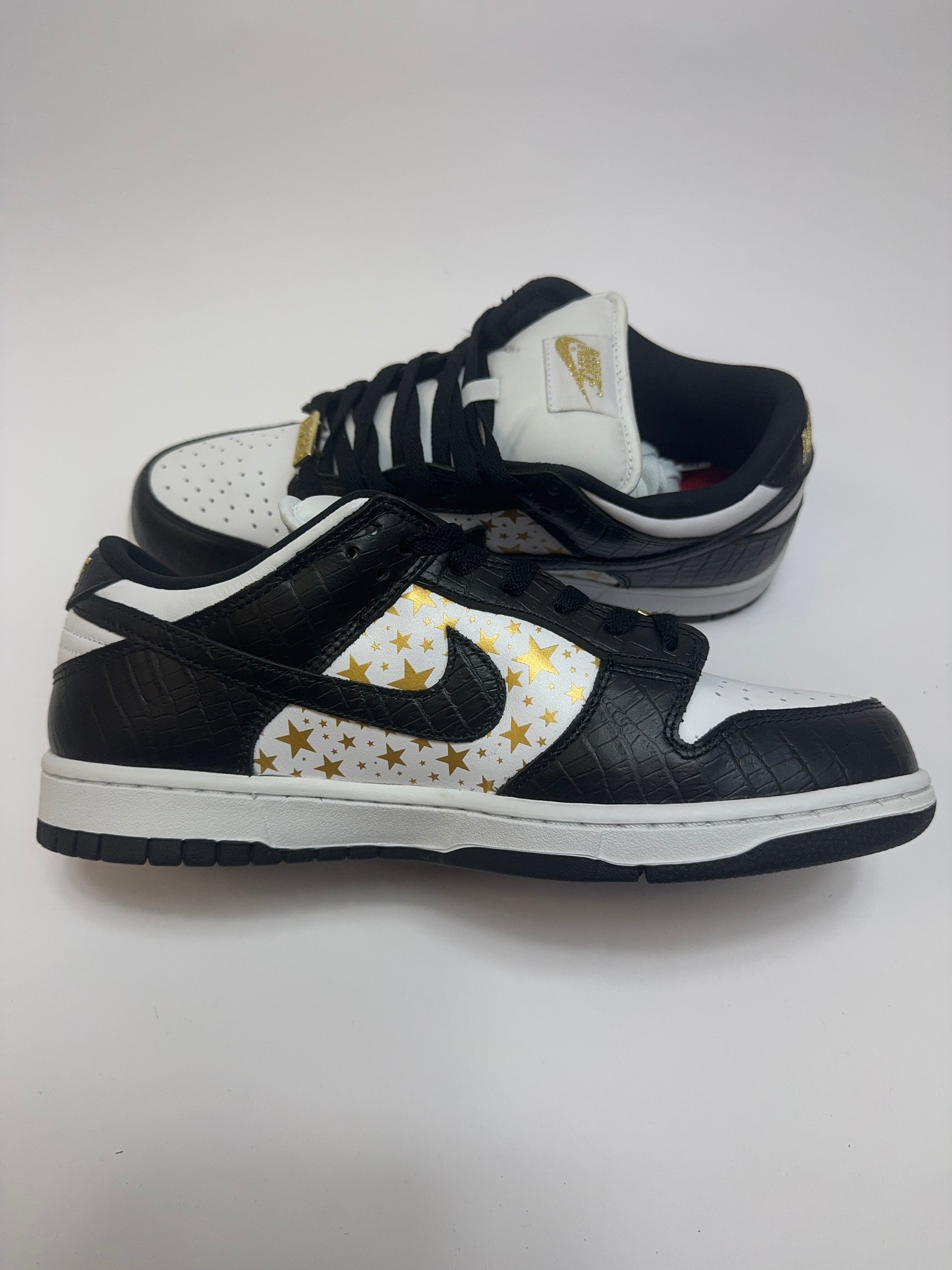 Supreme SB Dunk Low Black Stars linke Außenseite – goldene Sterne über schwarzem Leder