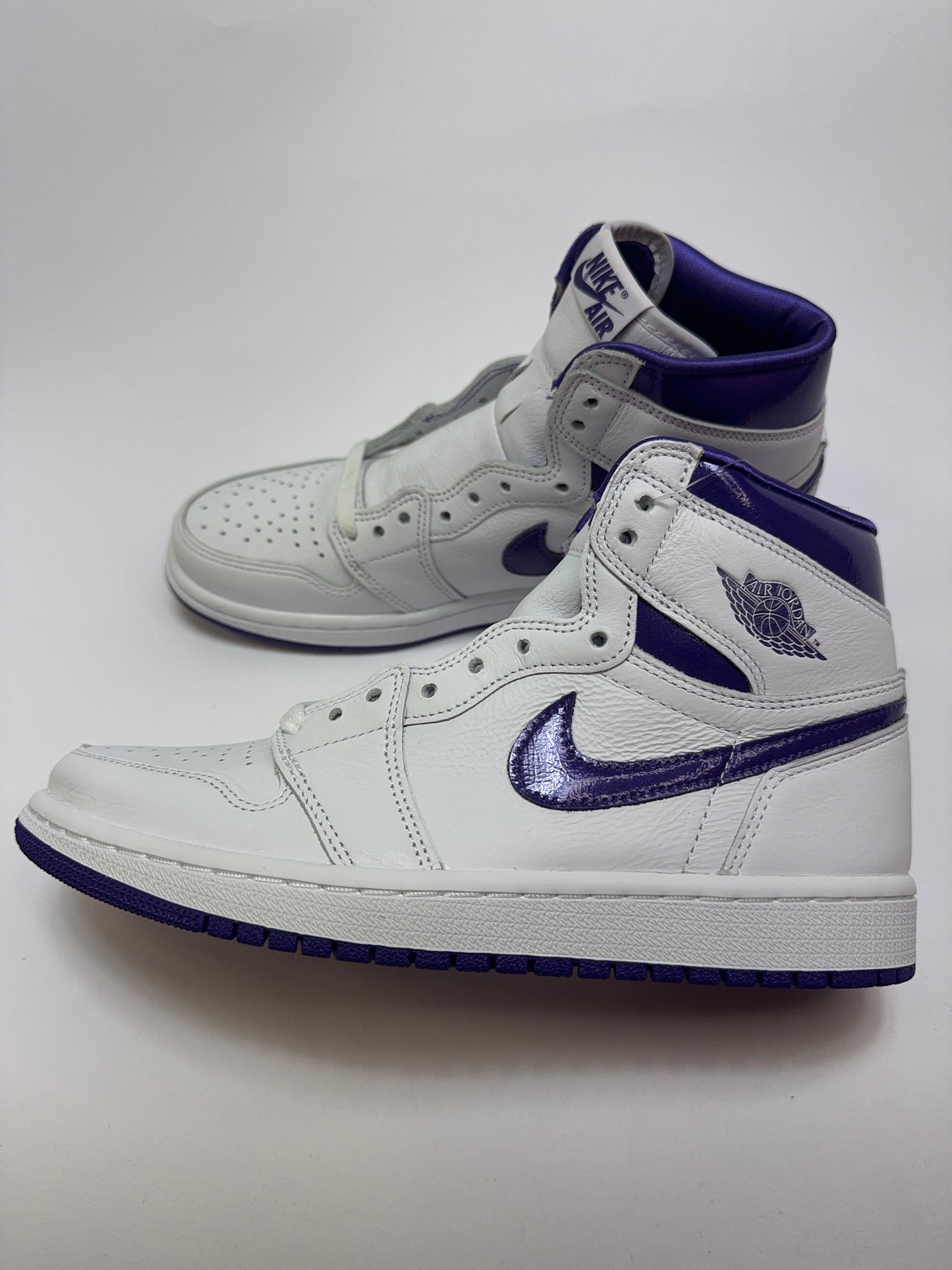 Seitenansicht des Air Jordan 1 Retro High Court Purple mit weißem Leder-Upper, schwarzen Details und Court-Purple-Overlays