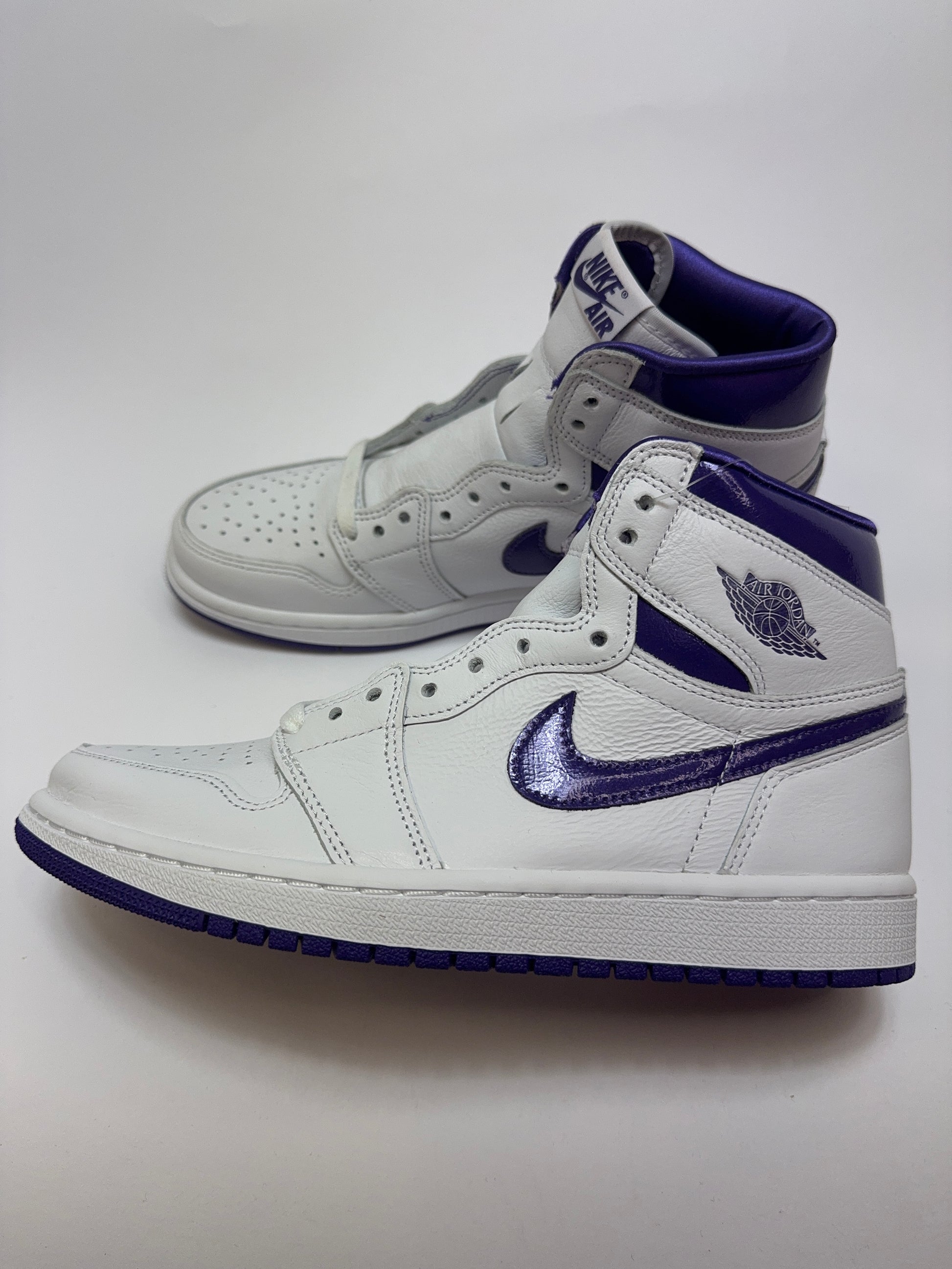 Seitenansicht des Air Jordan 1 Retro High Court Purple mit weißem Leder-Upper, schwarzen Details und Court-Purple-Overlays