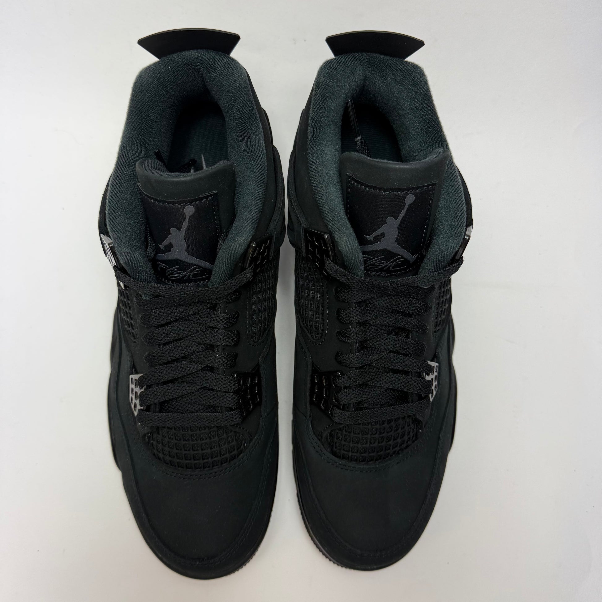 Draufsicht auf beide Air Jordan 4 Black Cat 2025 mit schwarzer Schnürung und monochromem Design