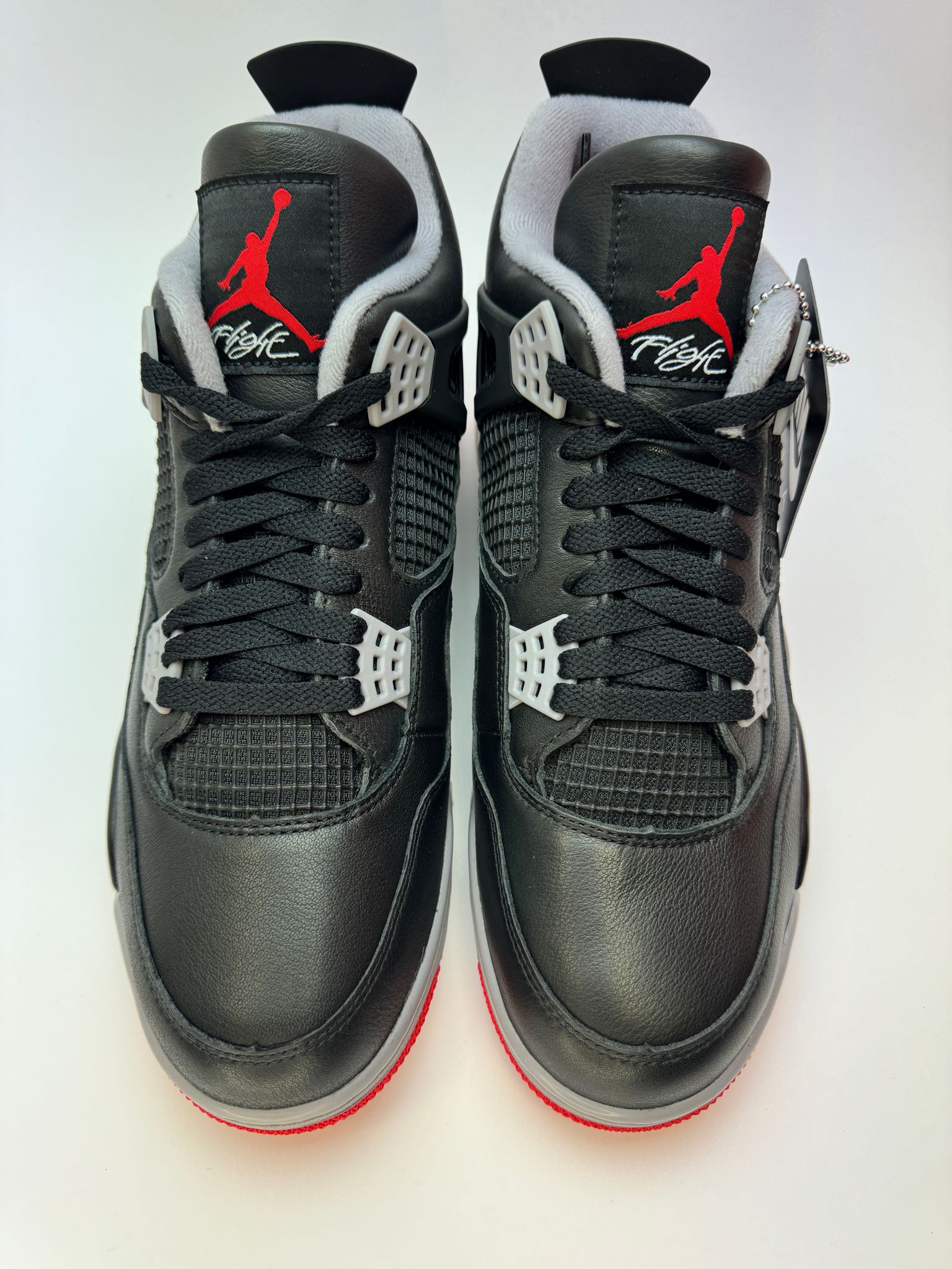 Rückansicht des Sneakers – Air Jordan 4 Retro Bred Reimagined mit vergrößertem Gummietikett an der Ferse