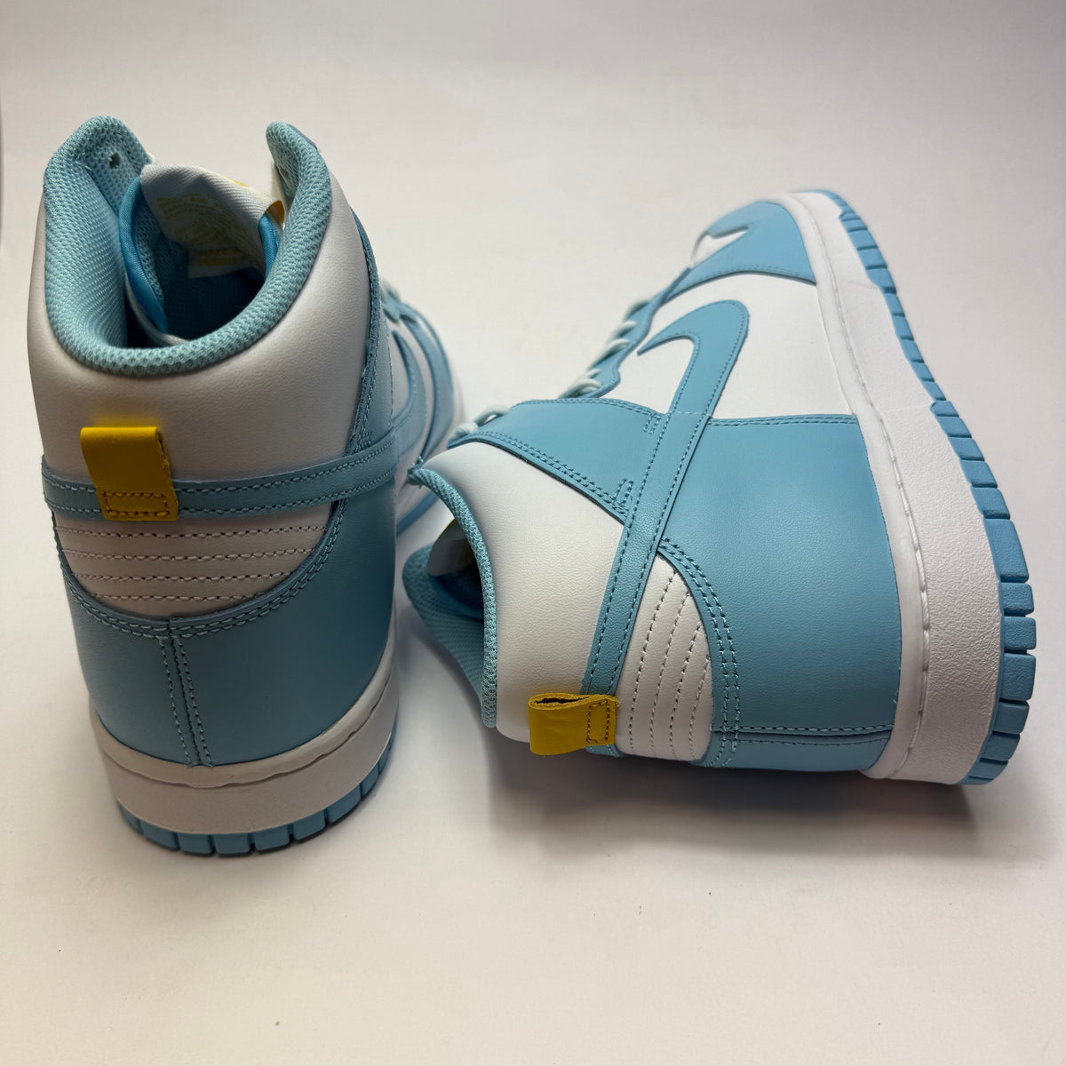 Rückansicht des Nike Dunk High Blue Chill mit hellblauen Leder-Overlays und kontrastierendem gelbem Heel-Detail