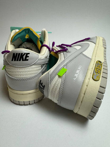 Rückansicht des Sneakers – Off‑White Dunk Lot 21 mit grünem, exponiertem Schaum-Zungenrand und rotem Tag-Detail